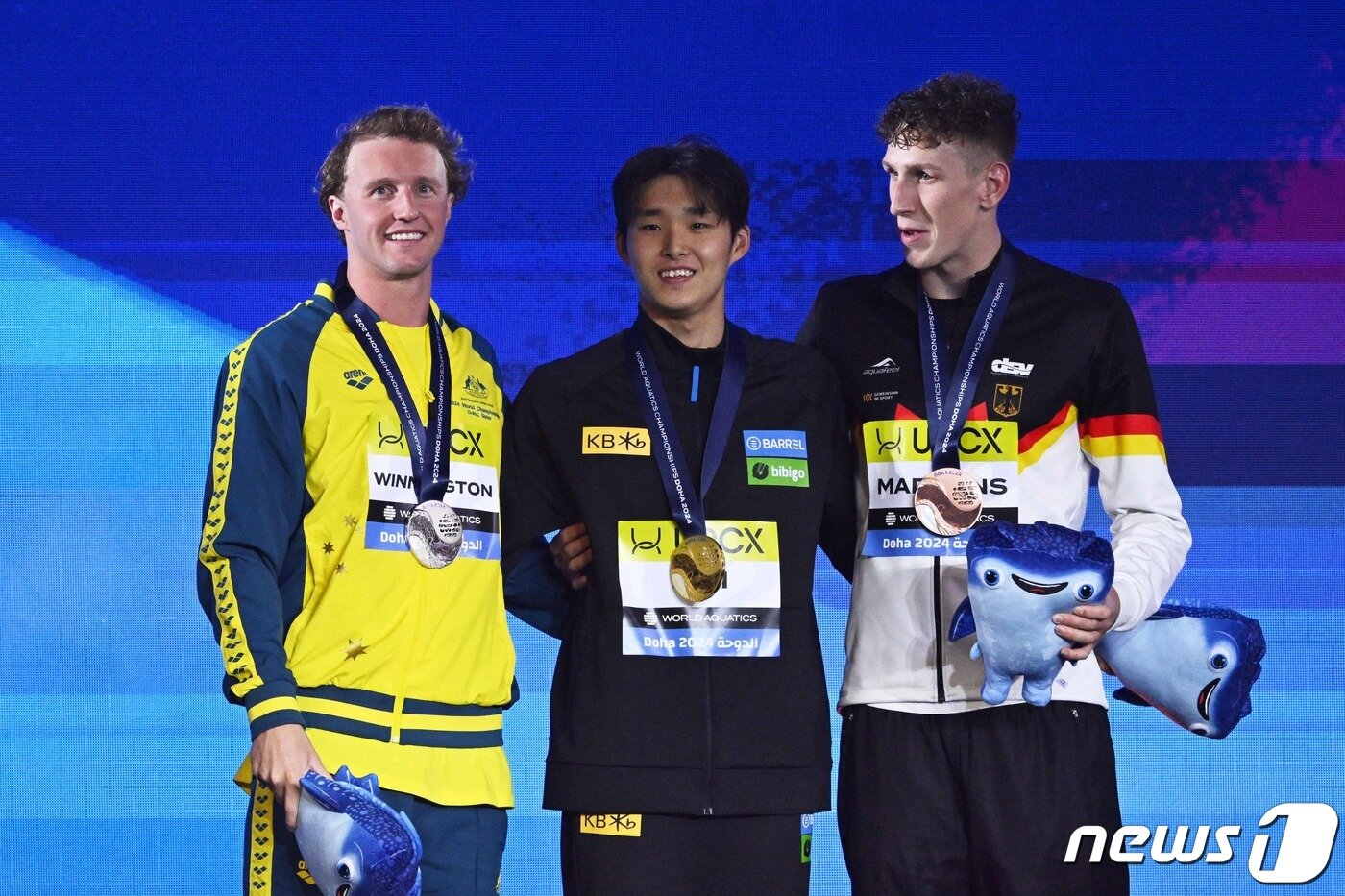 본문 이미지 - 12일(한국시간) 카타르 도하 어스파이어돔에서 열린 2024 국제수영연맹 세계선수권대회 경영 남자 자유형 400m 결승에서 우승하며 금메달을 획득한 대한민국 수영 경영의 중장거리 간판 김우민(강원도청)이 시상식에서 은메달을 획득한 호주의 일라이자 위닝턴, 동메달을 획득한 루카스 마르텐스와 기념 촬영을 하고 있다. ⓒ AFP=뉴스1 ⓒ News1 김진환 기자