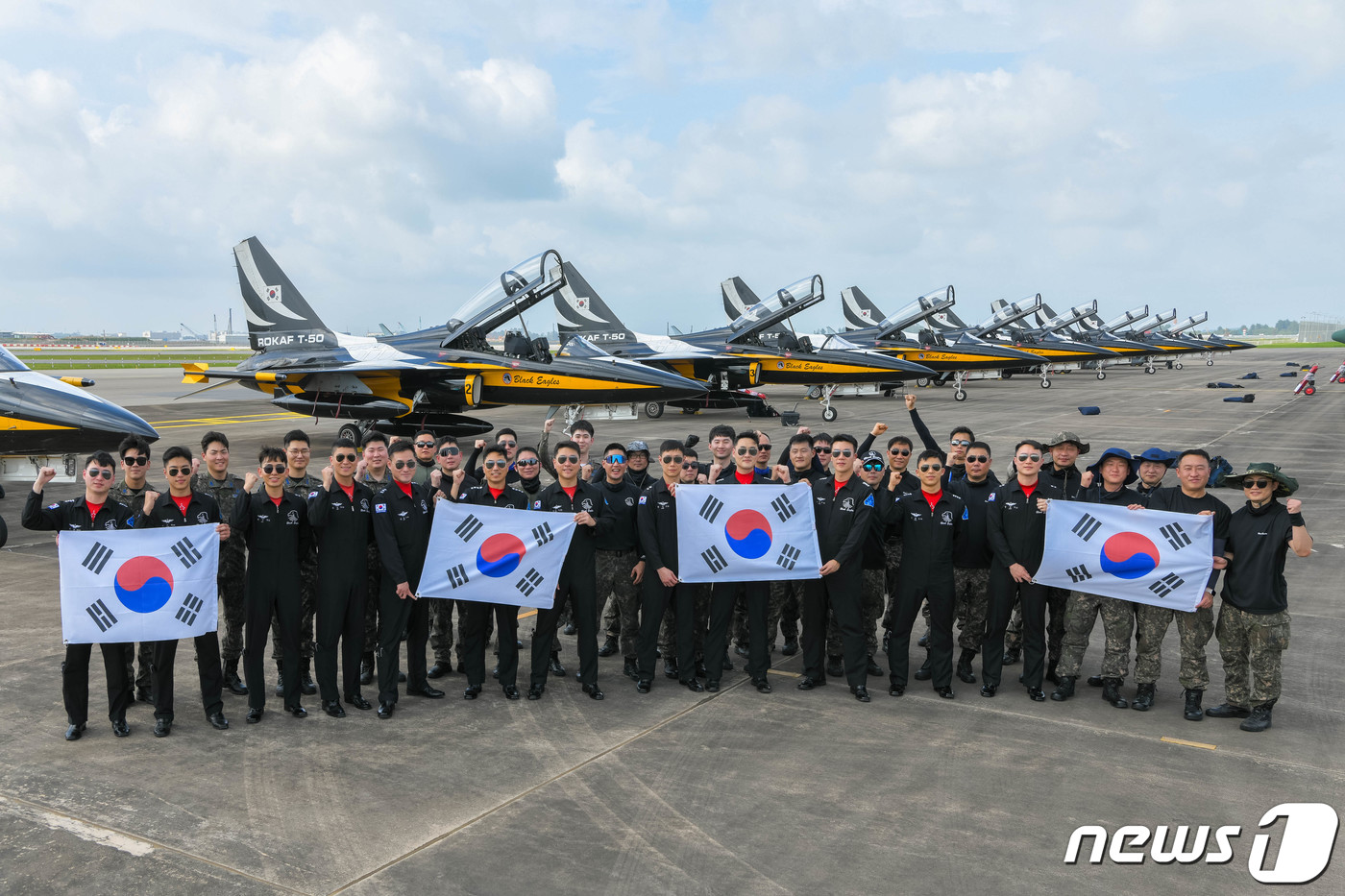 (서울=뉴스1) = 공군 특수비행팀 블랙이글스(Black Eagles) 임무요원들이 13일 에어쇼 참가를 위해 싱가포르 창이 국제공항에 도착한 뒤 태극기를 흔들며 기념 촬영하고 있 …