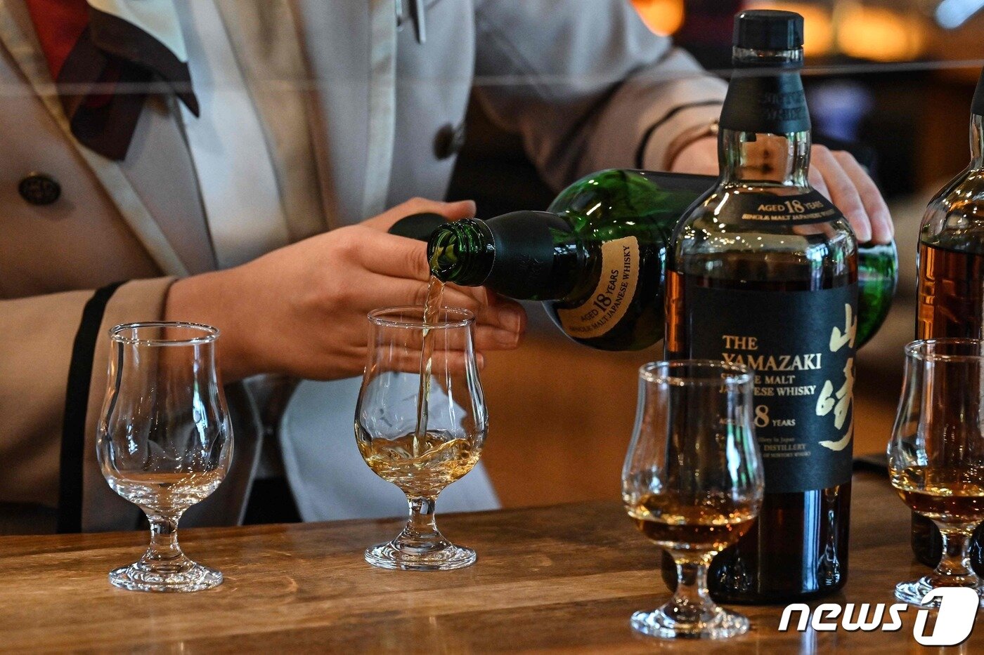 본문 이미지 - 일본 야마자키 증류소 내 마련된 바에서 한 직원이 야마자키 싱글몰트 18년산 시음을 준비하고 있다. 2023.3.27/ ⓒ AFP=뉴스1 ⓒ News1 권진영 기자