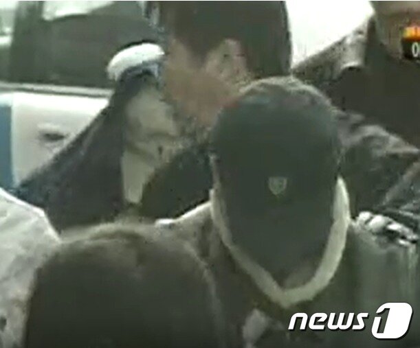 본문 이미지 -  2006년 2월 17일 밤 용산 초등생을 성폭행하려다 미수에 그친 뒤 살해한 김장호(검은 모자)와 아버지를 도와 시신을 불태우는 등 훼손한 아들(뒤 하얀 모자)이 2006년 2월 20일 현장검증을 받기 위해 신발가게 안으로 들어서고 있다. (YTN 갈무리) ⓒ 뉴스1