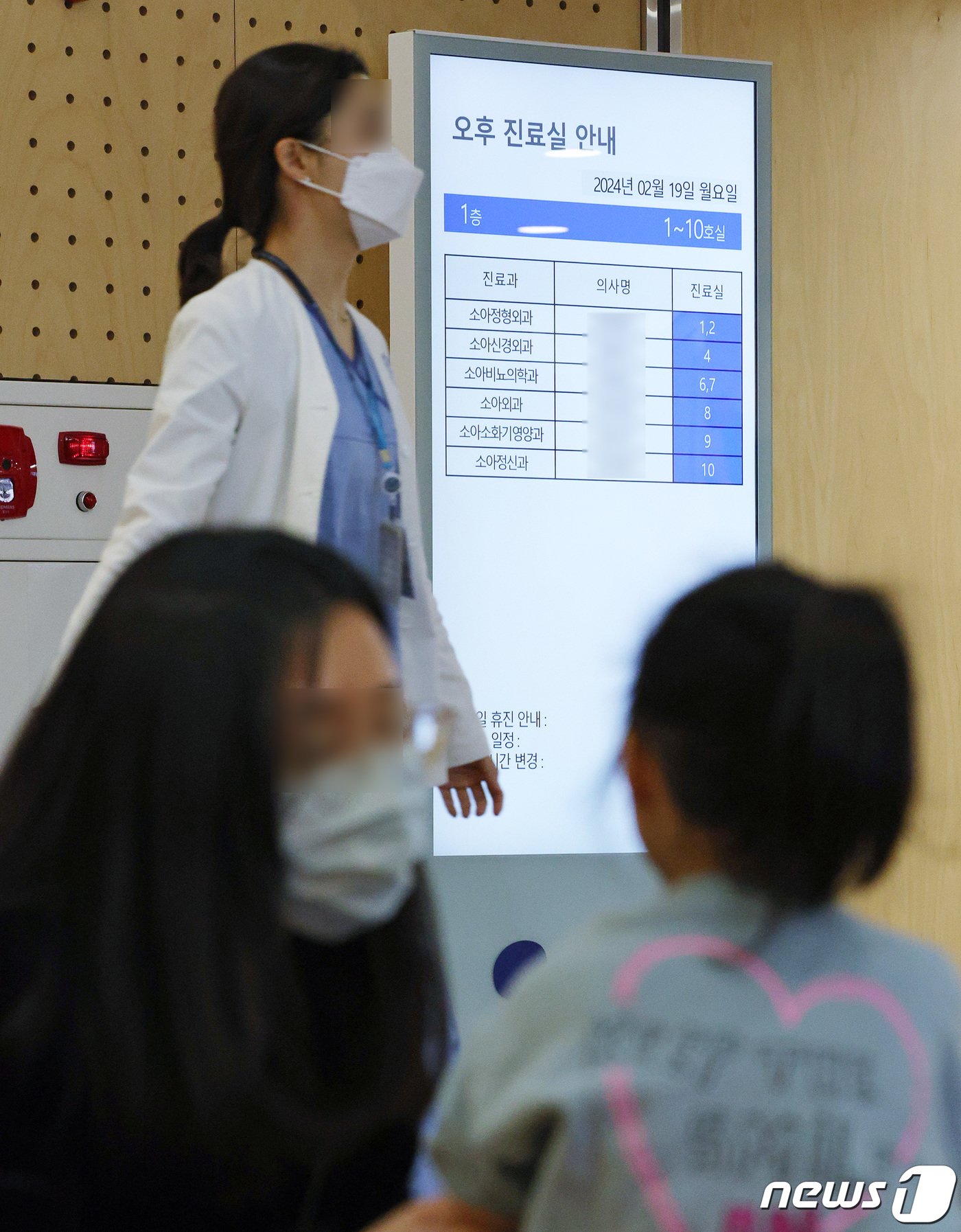 본문 이미지 - 19일 오전 서울 서대문구 연세 세브란스 어린이병원에서 진료를 기다리는 어린이 가족 뒤로 의료진이 지나가고 있다.  2024.2.19/뉴스1 ⓒ News1 장수영 기자