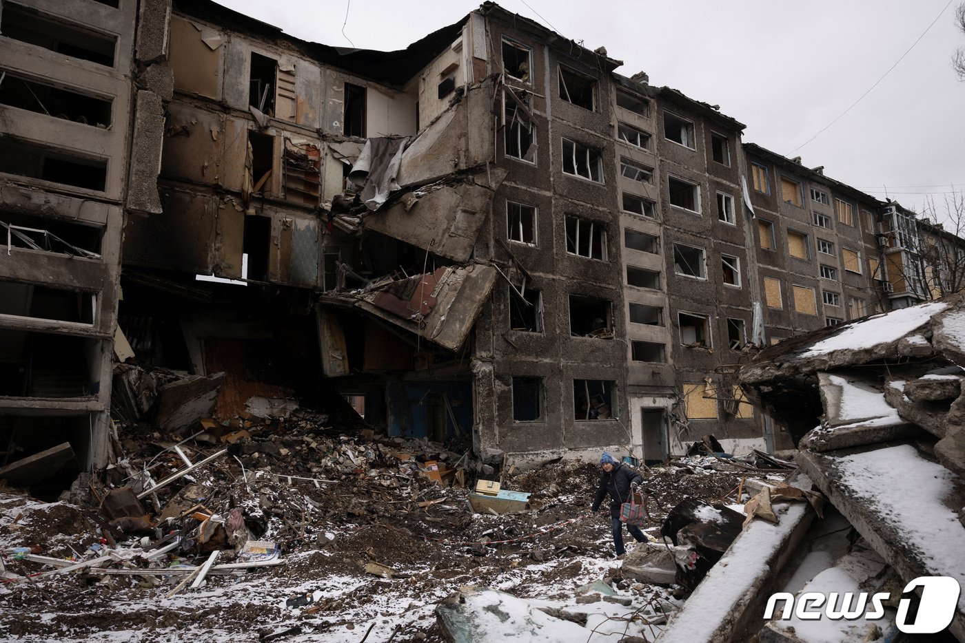 본문 이미지 - 19일(현지시간) 러시아가 우크라이나 아우디우카를 점령한 가운데 한 여성이 아우디우카 인근 셀리도브 마을의 파괴된 아파트 사이를 지나가고 있다. 24.02.19 ⓒ 로이터=뉴스1 ⓒ News1 김예슬 기자