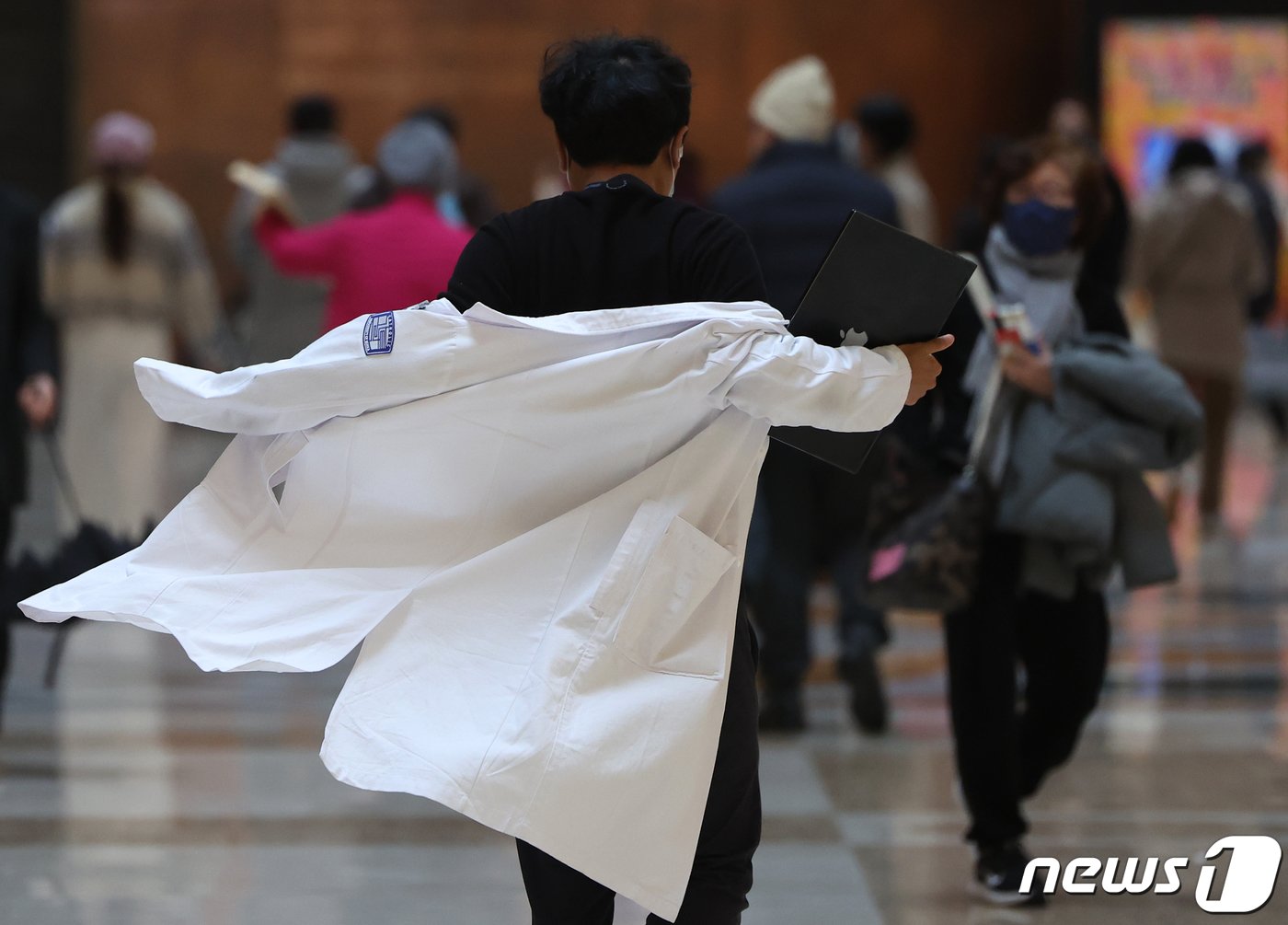본문 이미지 - 정부의 의대 정원 확대에 반발하는 전공의들의 집단 진료거부로 인한 의료대란이 우려되고 있는 21일 오후 서울의 한 대학병원에서 한 의료진이 가운을 입으며 발걸음을 옮기고 있다. 2024.2.21/뉴스1 ⓒ News1 김진환 기자