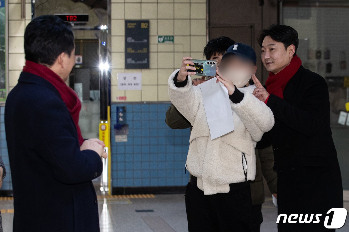 본문 이미지 - 22일 인천 계산역 내에서 인천 계양을에 출마한 원희룡 전 국토교통부 장관이 한 시민과 기념 촬영하는 전 축구 국가대표 이천수를 바라보고 있다. 2024.2.22/뉴스1 ⓒ News1 유승관 기자