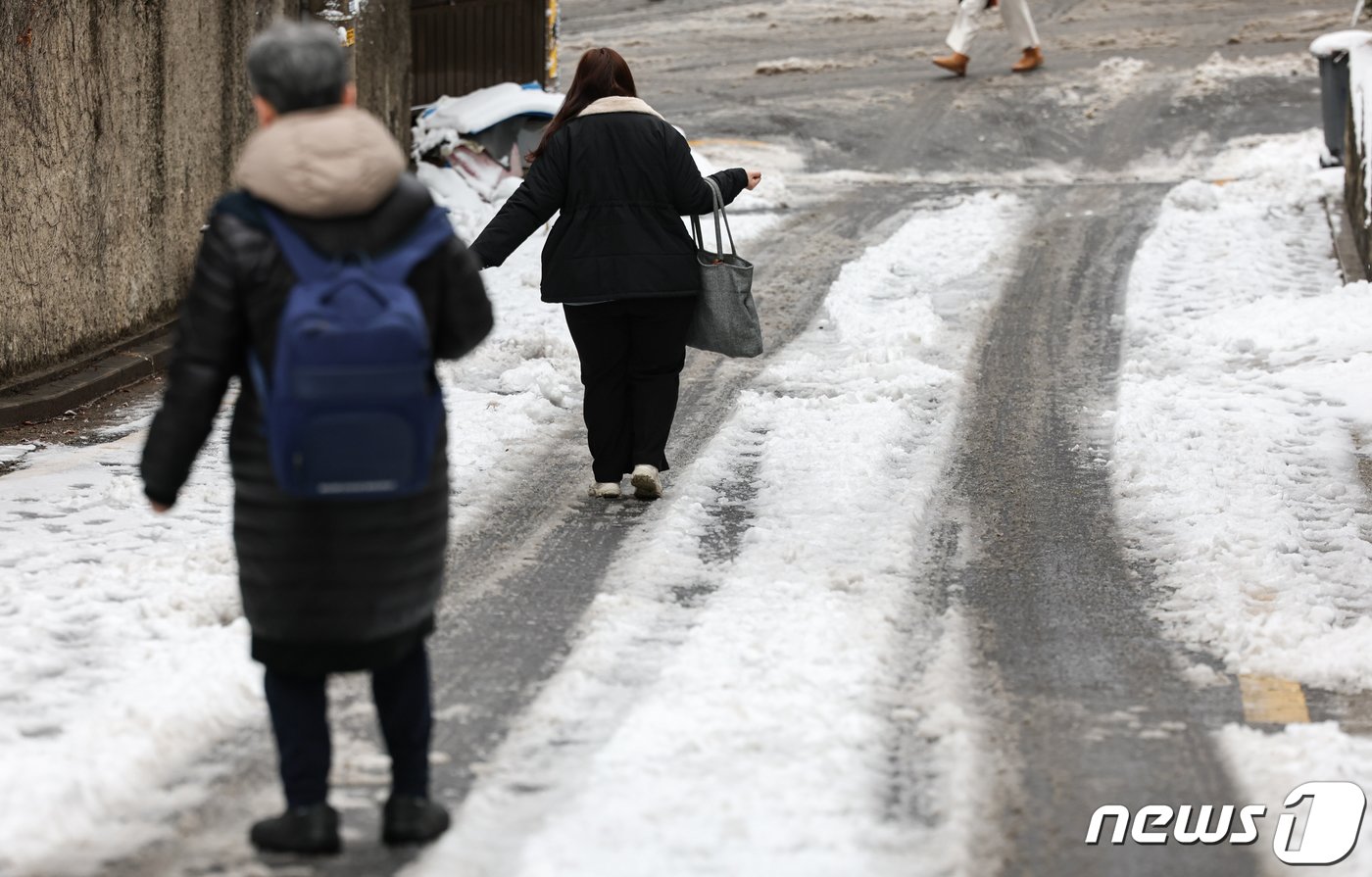 22일 서울 마포구 한 골목길에서 시민들이 눈 쌓인 언덕길을 조심스레 걷고 있다. 2024.2.22/뉴스1 ⓒ News1 김도우 기자