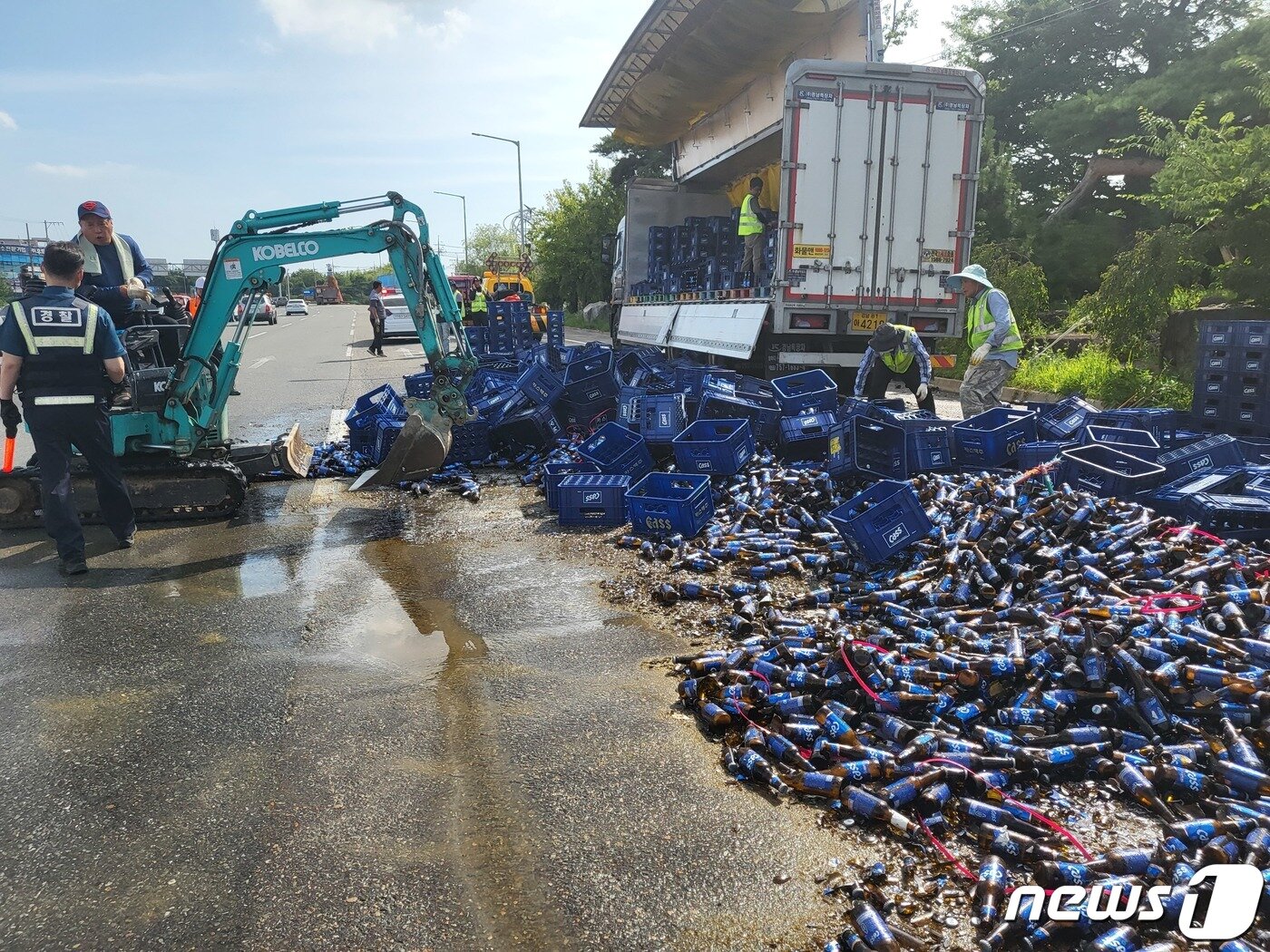 본문 이미지 - 경남 사천시 축동면 사천IC 나들목 인근 급커브 도로에서 지난 2022년 7월 27일 18톤 화물차 적재함에 실려 있던 맥주 500여박스가 도로에 쏟아졌다. 2022.07.27 뉴스1/한송학기자