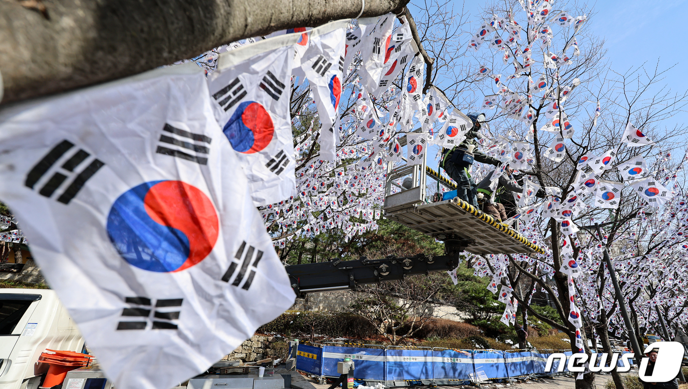 (서울=뉴스1) 김도우 기자 = 3·1절을 일주일 앞둔 23일 서울 용산구 효창공원 일대에서 작업자들이 가로수에 태극기를 게양하고 있다.용산구는 제105주년 3·1절을 기념해 다음 …