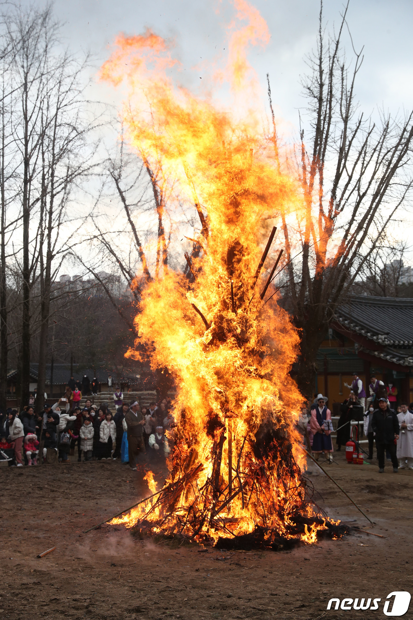 (용인=뉴스1) 김영운 기자 = 25일 오후 경기 용인시 기흥구 한국민속촌에서 열린 정원대보름 달집태우기 행사에서 시민들이 타오르는 달집을 바라보며 소원을 빌고 있다. 2023.2 …