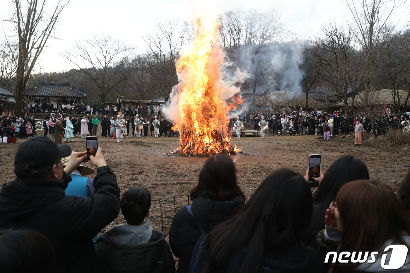 (용인=뉴스1) 김영운 기자 = 25일 오후 경기 용인시 기흥구 한국민속촌에서 열린 정원대보름 달집태우기 행사에서 시민들이 타오르는 달집을 바라보며 소원을 빌고 있다. 2023.2 …