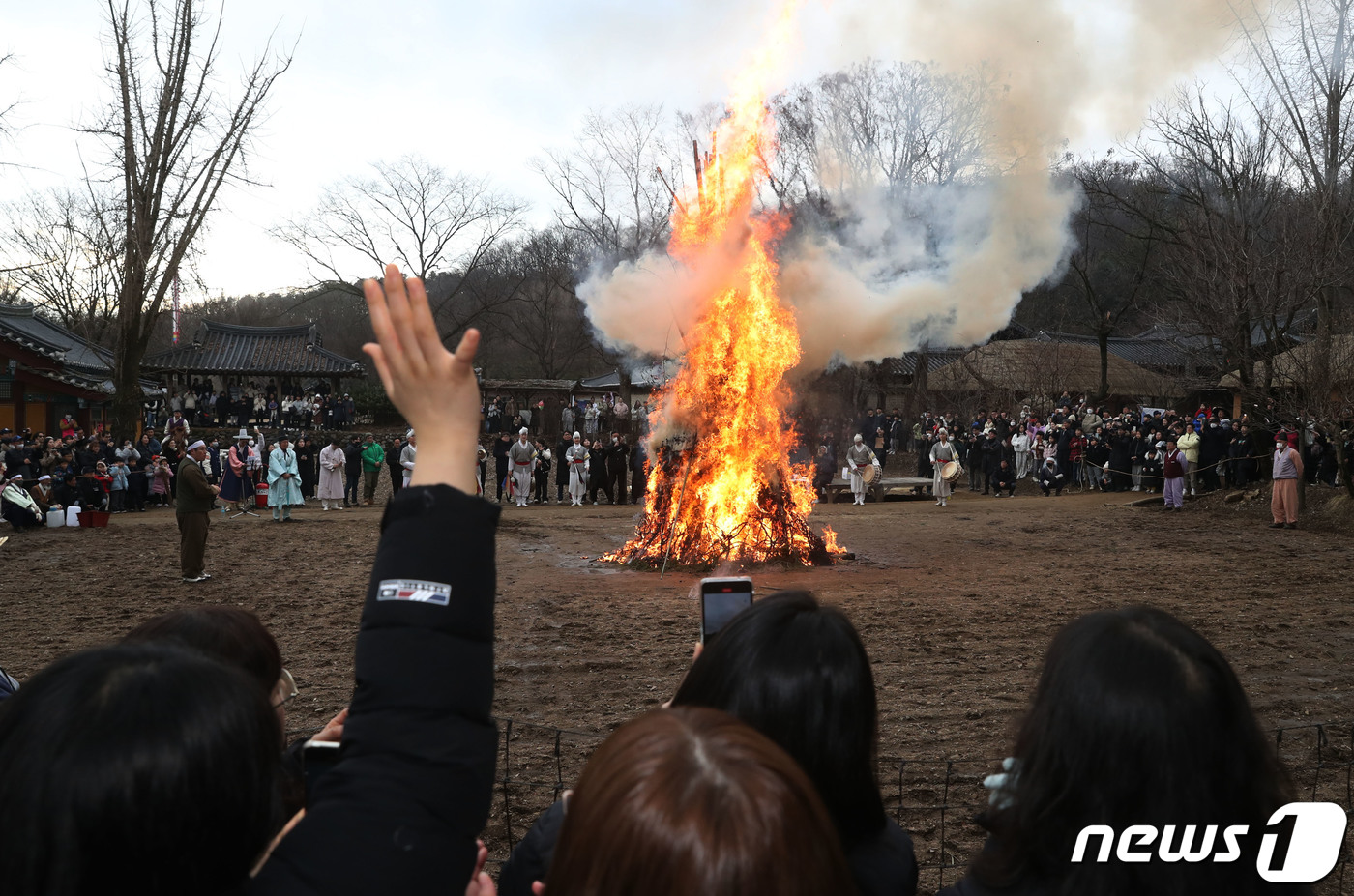 (용인=뉴스1) 김영운 기자 = 25일 오후 경기 용인시 기흥구 한국민속촌에서 열린 정원대보름 달집태우기 행사에서 시민들이 타오르는 달집을 바라보며 소원을 빌고 있다. 2023.2 …