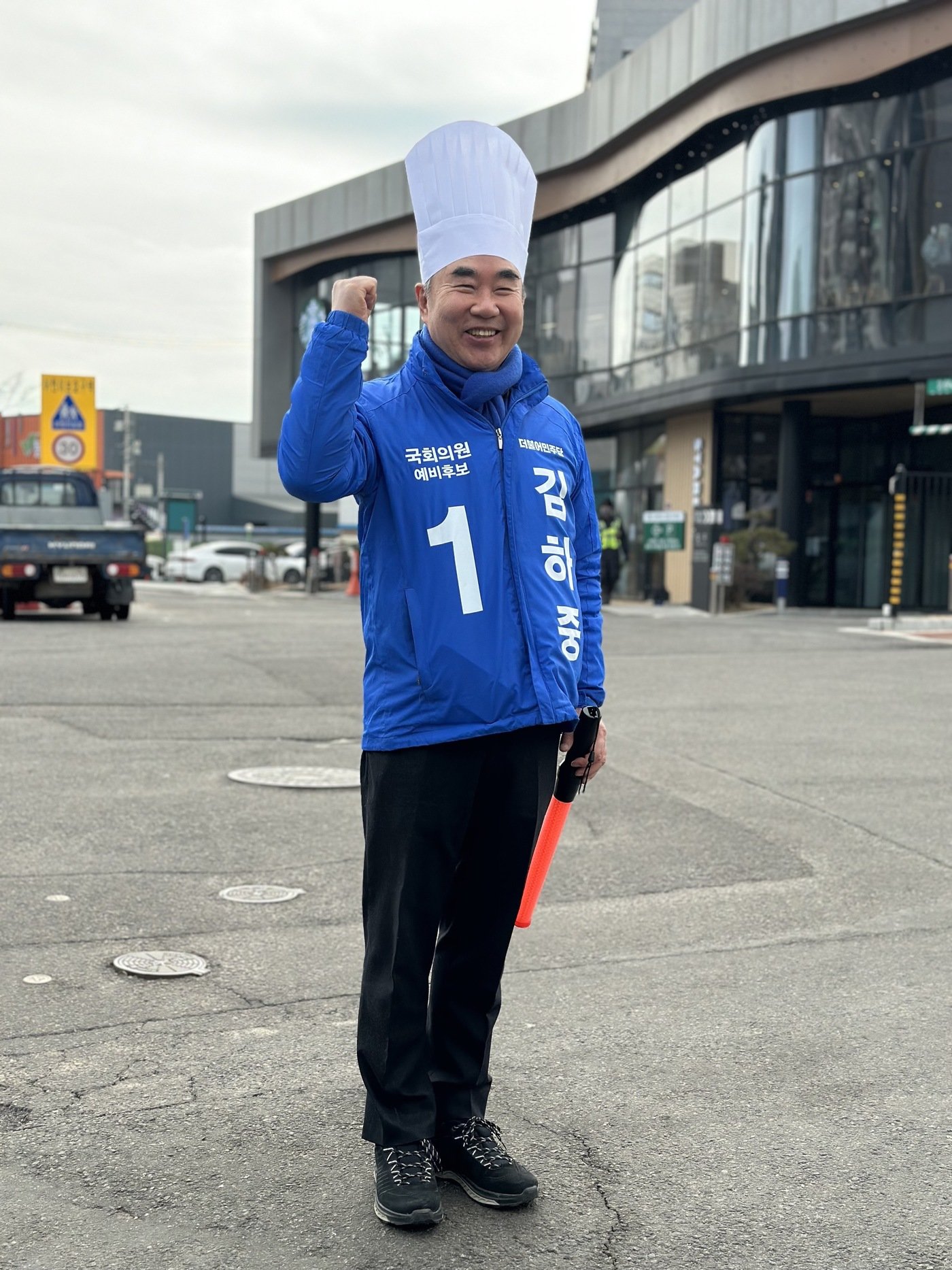 본문 이미지 - 더불어민주당 김하중 화성을 예비후보(63)가 주말을 맞아 제빵 모자를 쓰고 교통봉사에 나서 눈길을 끌었다.(김하중 예비후보 제공)/