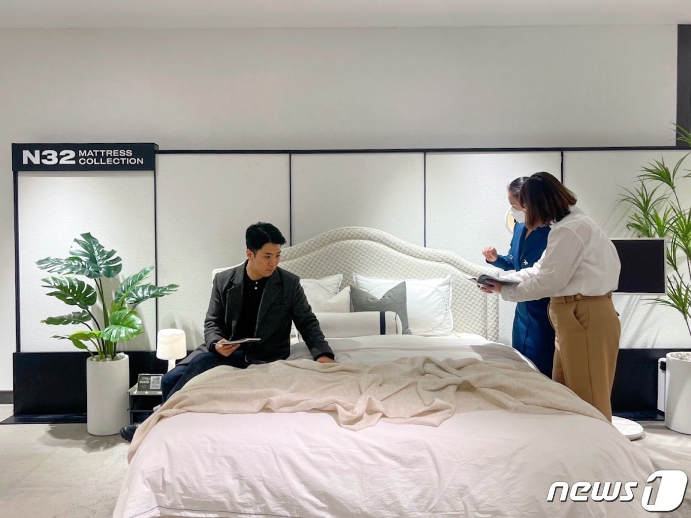 본문 이미지 - 신세계백화점 센텀시티점에 문을 연 N32 매장을 찾은 소비자가 매트리스에 앉아보고 있다. (시몬스 제공)