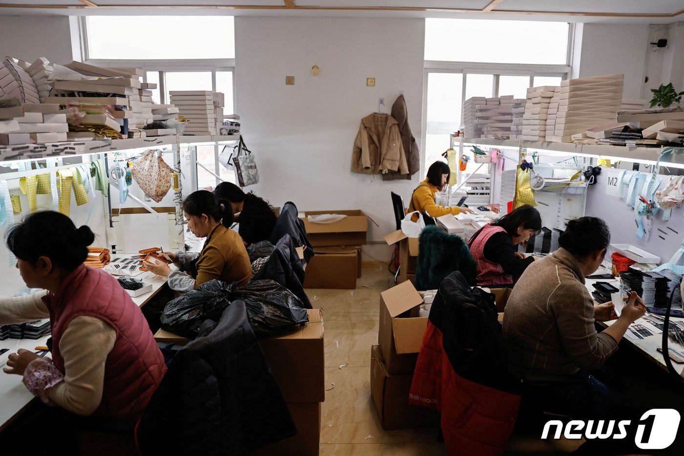 본문 이미지 - 중국 산둥성 핑두에 위치한 인조 속눈썹 공장에서 직원들이 업무에 몰두하고 있다. 2023.11.16 ⓒ 로이터=뉴스1 ⓒ News1 강민경 기자