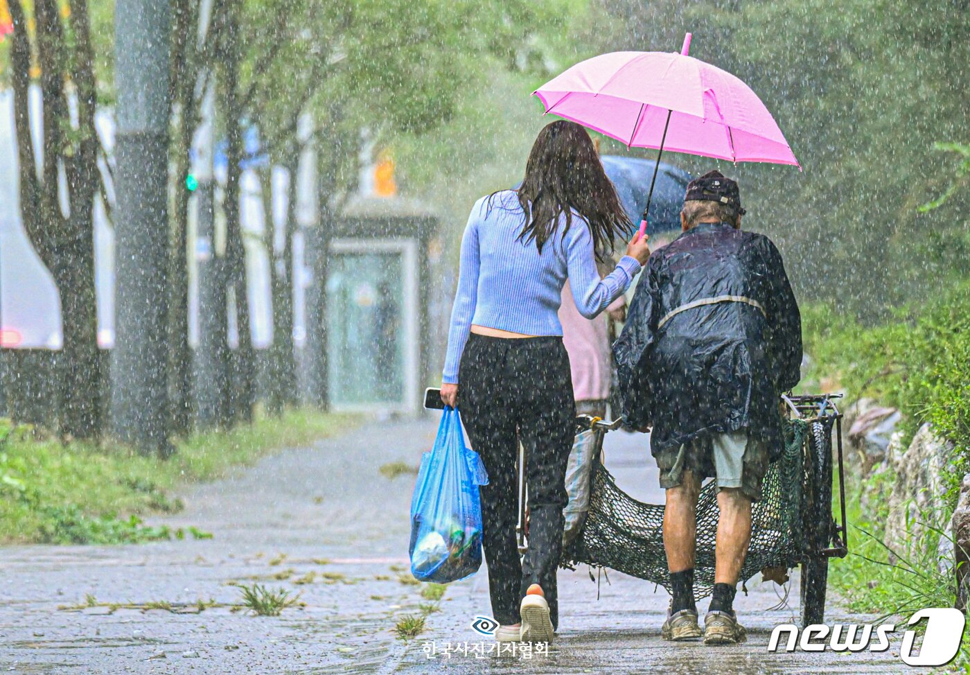 본문 이미지 - 한국보도사진상 피처 최우수상 '내 어깨는 다 젖어도' - 경기일보 조주현 기자천근만근 무거운 어깨 위로 굵은 빗줄기가 더해집니다. 한 걸음씩 내딛을 때마다 튀어오르는 회색빛 물방울이 발목을 붙잡아 오늘 하루를 마냥 지치게만 합니다. 화창한 날이었다면 '소중한 자산'이었을 폐지가 폭우 속에서는 '남루한 쓰레기'에 불과합니다. 그때, 비가 그칩니다. 하늘에선 끊임 없이 내리는데 머리 위에서만 화창합니다. 안산시 단원구의 한 거리에서 만난 분홍색 우산의 여성은 리어카를 끄는 어르신을 따라 한참을 조용히 걸었습니다. 우산을 한껏 기울여 자신의 몸은 몽땅 젖은 채 "특별한 일도, 별다른 일도 아니다＂라며 한사코 신분을 밝히길 거부했습니다. 흉흉한 범죄가 빈번해지며 '낯선 이'의 접근이 두렵고 '모르는 이'의 친절이 의심스러운 시대. 콘크리트 사회 속 작은 유토피아에 조금은 감동 받아도 되지 않을까요?   