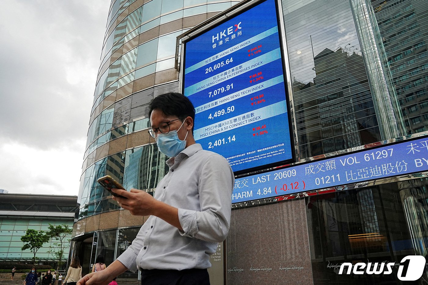 본문 이미지 - 홍콩의 한 시민이 홍콩증권거래소의 전광판 앞을 지나가고 있다. ⓒ 로이터=뉴스1 ⓒ News1 박형기 기자