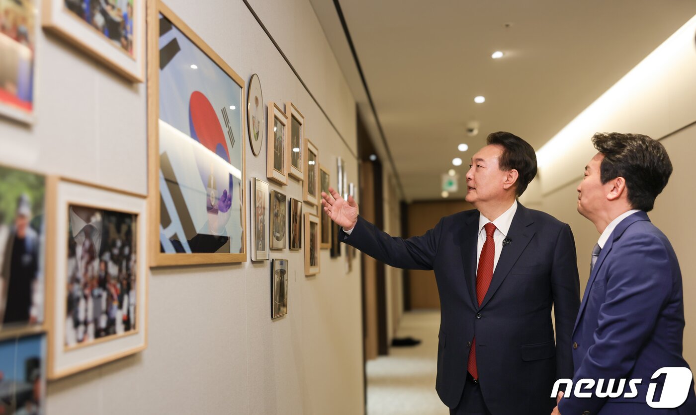 본문 이미지 - 윤석열 대통령이 지난 4일 용산 대통령실 청사 집무실에서 진행된 KBS 신년 대담에 앞서 박장범 KBS 앵커에게 복도에 걸린 사진을 소개하고 있다. (대통령실 제공) 2024.2.7/뉴스1 ⓒ News1 오대일 기자