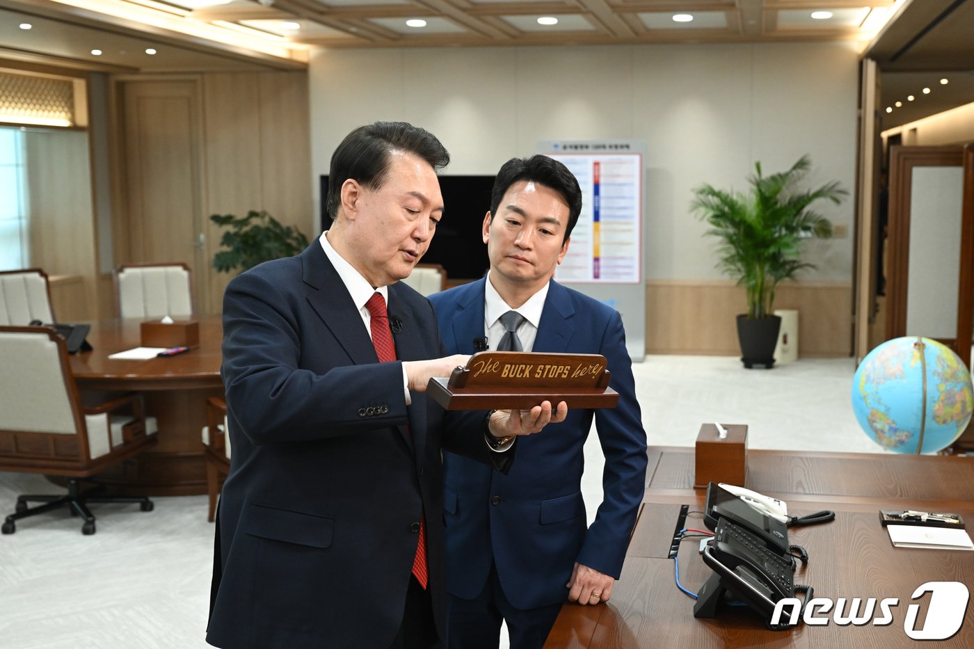 본문 이미지 - 윤석열 대통령이 지난 4일 용산 대통령실 청사 집무실에서 진행된 KBS 신년 대담을 마친 후 박장범 KBS 앵커에게 바이든 미국 대통령에게 선물한 팻말을 소개하고 있다. (대통령실 제공) 2024.2.7/뉴스1 ⓒ News1 오대일 기자