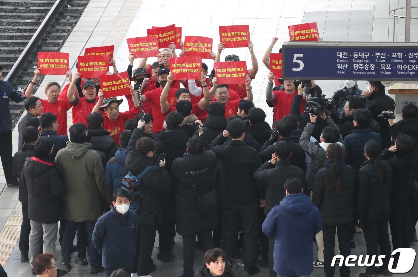 본문 이미지 - 해병대 전역자들이 8일 오전 서울 용산구 서울역에서 시민들에게 설 명절 귀성인사를 하는 한동훈 국민의힘 비상대책위원장 앞에서 채상병 특검 통과 촉구 피켓을 들고 기습 시위를 하고 있다. 2024.2.8/뉴스1 ⓒ News1 임세영 기자
