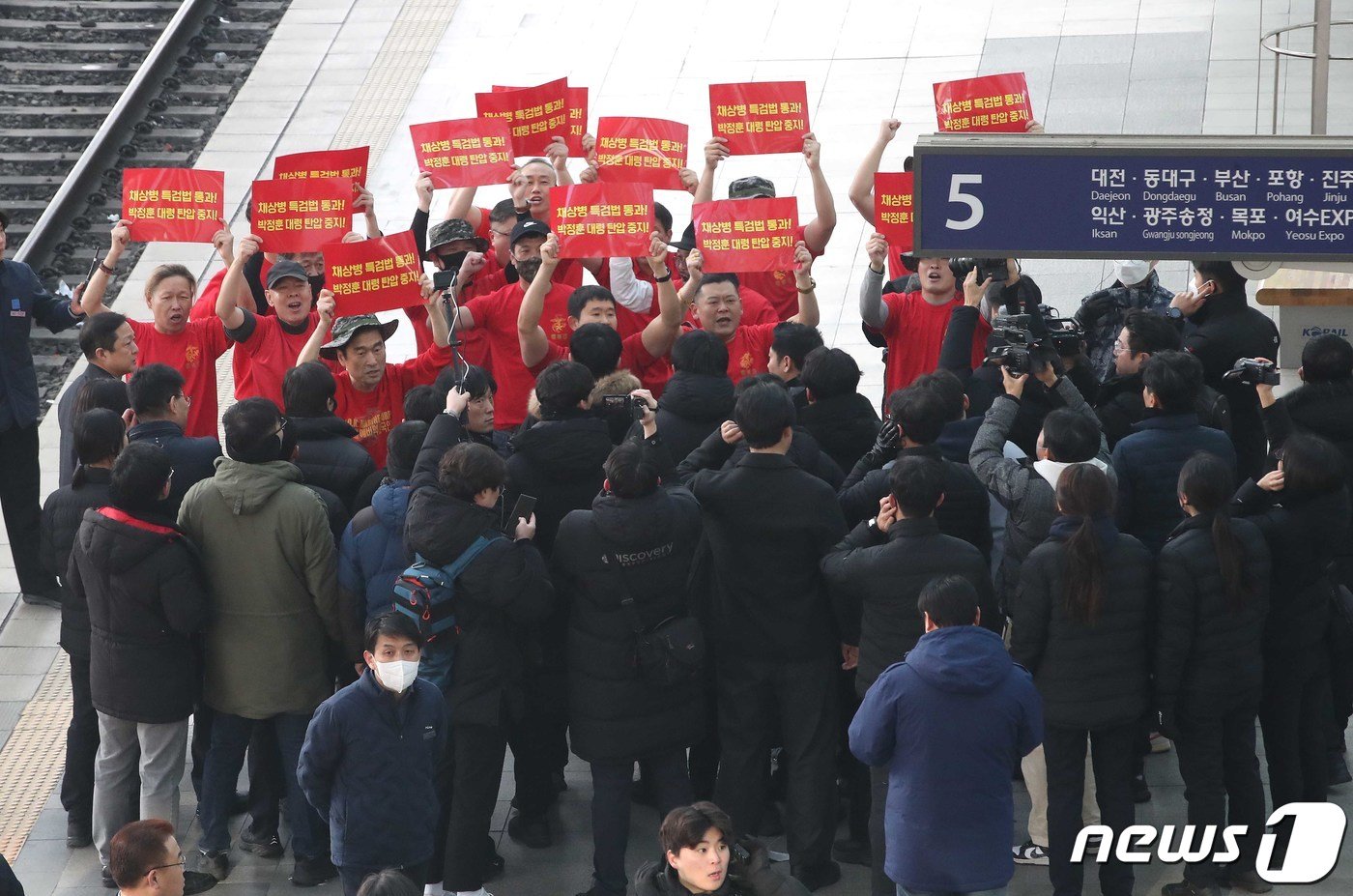 해병대 전역자들이 8일 오전 서울 용산구 서울역에서 시민들에게 설 명절 귀성인사를 하는 한동훈 국민의힘 비상대책위원장 앞에서 채상병 특검 통과 촉구 피켓을 들고 기습 시위를 하고 있다. 2024.2.8/뉴스1 ⓒ News1 임세영 기자