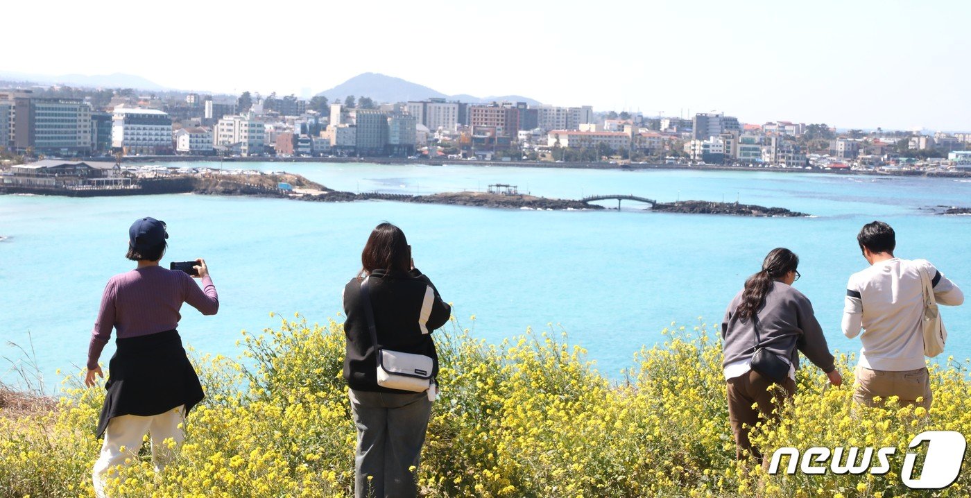 10일 제주도민과 관광객 등이 제주시 조천읍 서우봉에 핀 유채꽃과 함덕 해수욕장을 배경으로 사진촬영을 하고 있다.2024.3.10./뉴스1 ⓒ News1 강승남 기자