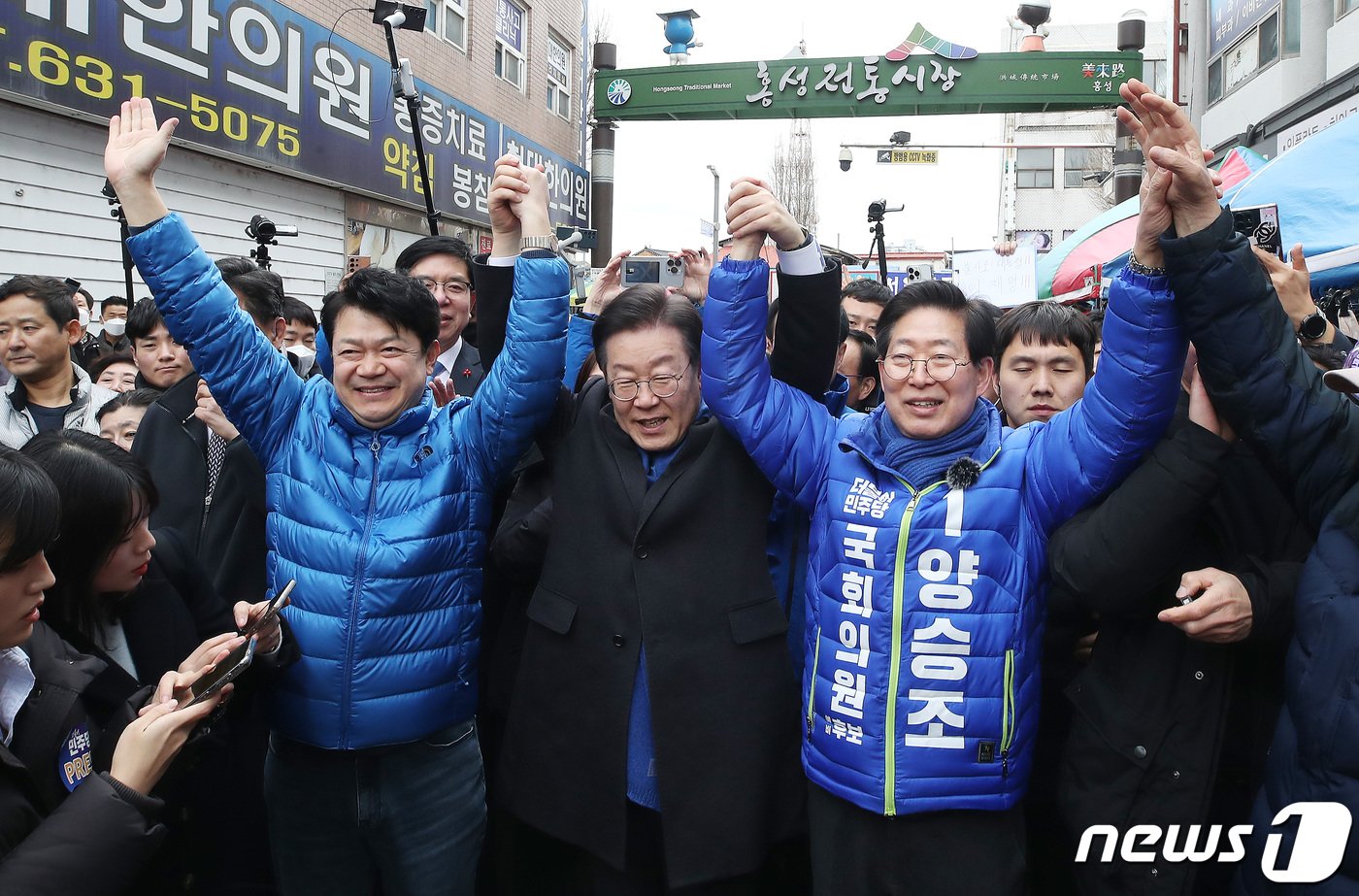 이재명 더불어민주당 대표가 11일 충남 홍성군 홍성시장을 방문해 복기왕 충남 아산시갑 국회의원 후보와 양승조 홍성·예산 국회의원 후보의 손을 들어 올리고 있다. 2024.3.11/뉴스1 ⓒ News1 임세영 기자