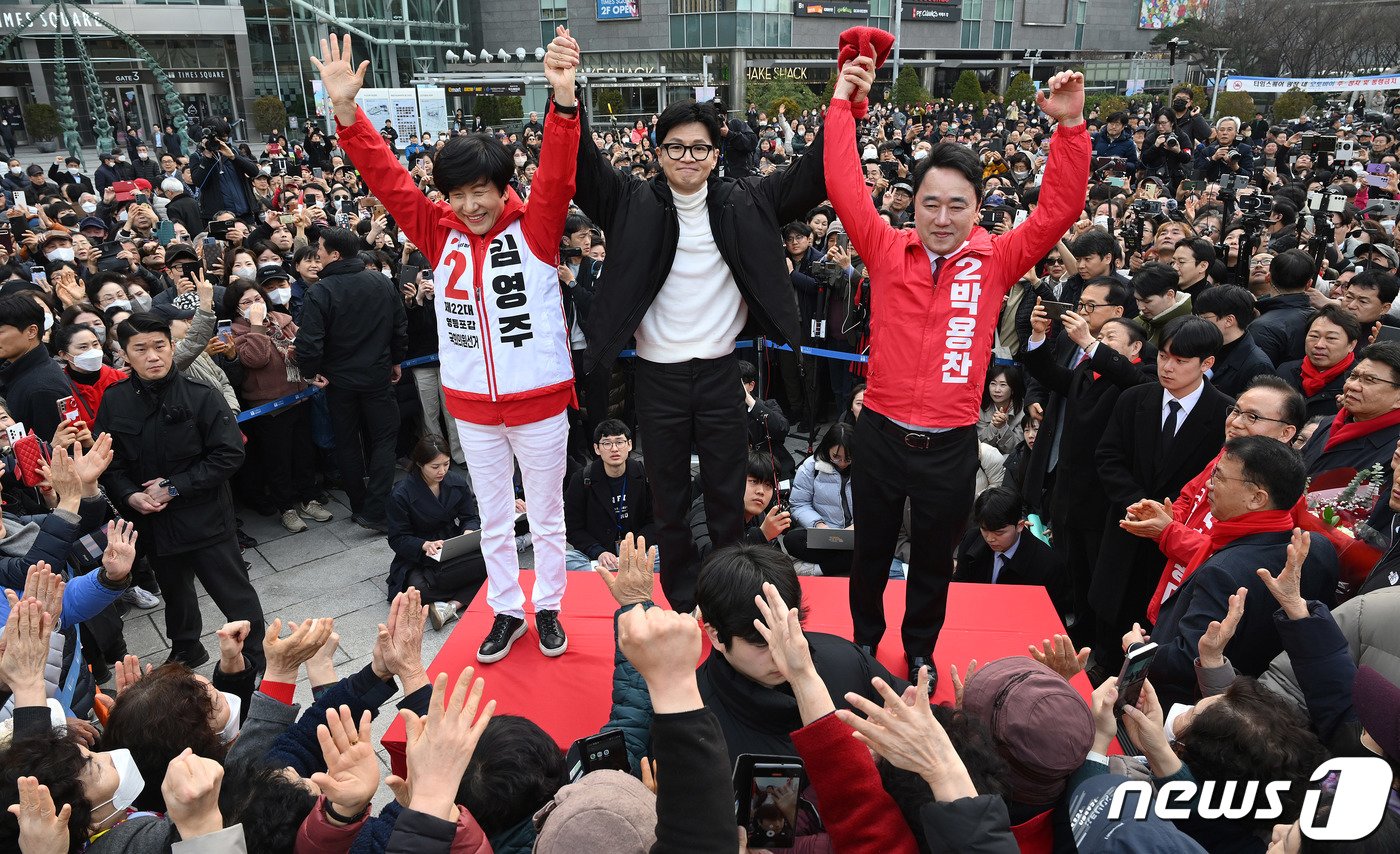 한동훈 국민의힘 비상대책위원장이 12일 서울 영등포구 타임스퀘어에서 김영주&#40;영등포갑&#41;·박용찬&#40;영등포을&#41; 후보의 손을 들어 올리고 있다. &#40;공동취재&#41; 2024.3.12/뉴스1 ⓒ News1 송원영 기자