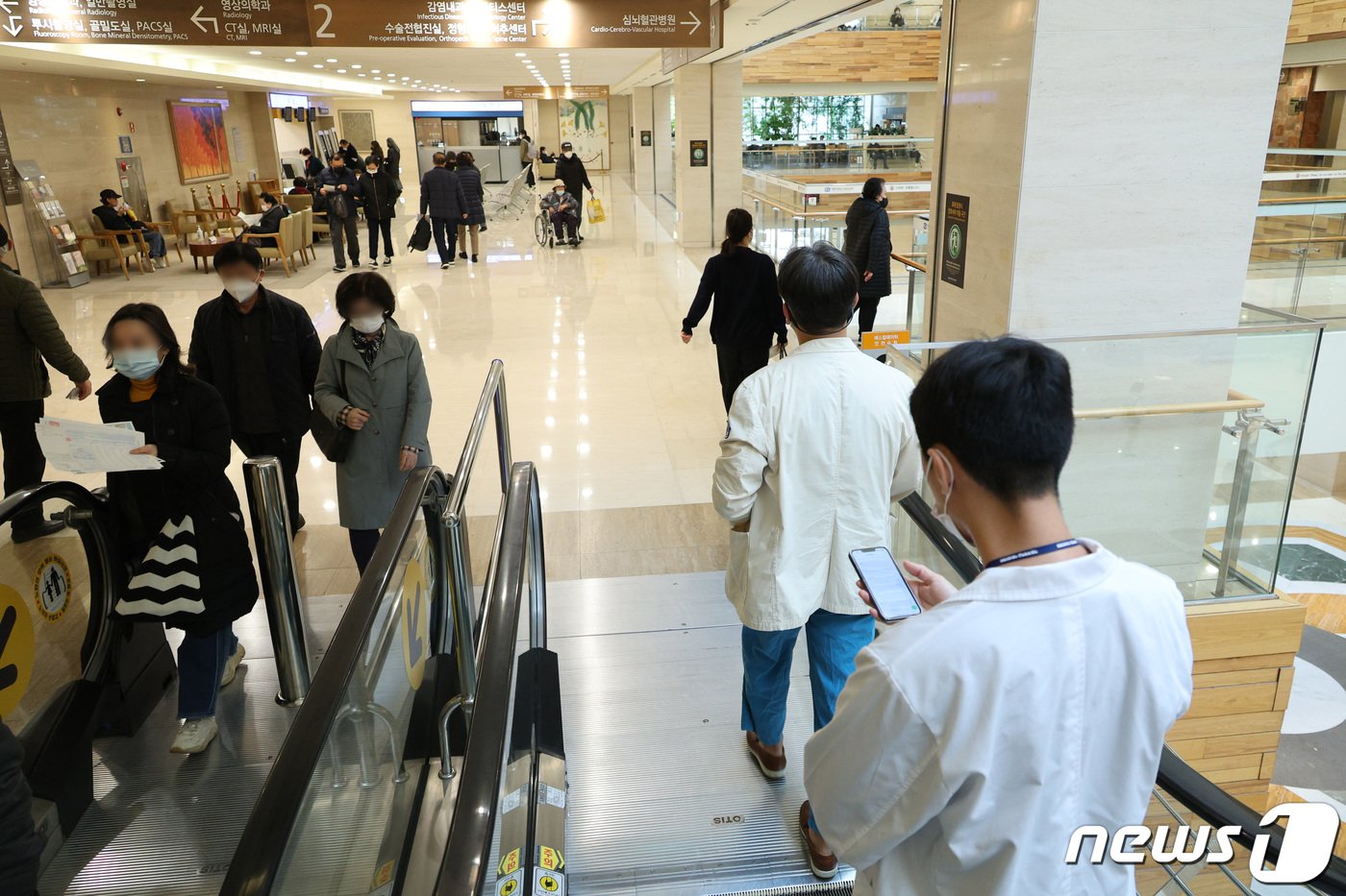 본문 이미지 - 의대정원 증원에 반대하는 전공의들의 집단 행동이 이어지고 있는 13일 서울의 한 종합병원에서 의료진이 로비를 지나고 있다. 서울의대-서울대병원 비상대책위원회는 이날 보도자료를 통해 "40개 의과대학 중 비대위가 만들어진 19개 대학과 전날 저녁 1차 총회를 열고 의과대학 학생들의 학업과 전공의들의 수련 중단으로 인한 대한민국 의료 붕괴를 막기 위해 함께 행동하기로 결의했다＂고 밝혔다. 이에 따라 위원회는 오는 15일까지 소속 대학 교수와 수련병원 임상진료 교수의 의사를 물어 사직서 제출 여부를 결정하기로 했다. 2024.3.13/뉴스1 ⓒ News1 신웅수 기자