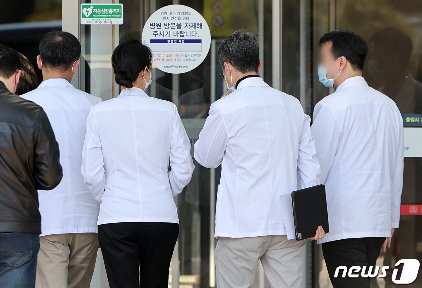 전국 19개 의과대학 교수들이 정부의 의대 증원 방침에 대응해 ‘전국 의과대학 교수 비상대책위원회’를 결성하고 오는 15일까지 소속 대학 교수와 수련병원 임상진료 교수의 의사를 물어 사직서 제출 여부를 결정하기로 했다. 사진은 13일 서울 종로구 연건동 서울대학교병원에서 이동하는 의료진들. 2024.3.13/뉴스1 ⓒ News1 김진환 기자