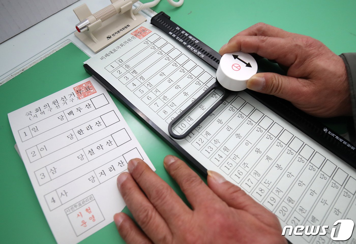 본문 이미지 - 4월 13일 실시되는 제20대 국회의원선거를 앞두고 13일 오후 대구 동구 장애인지역공동체에서 대구시선거관리위원회 주최로 열린 장애인유권자 모의 투표체험에서 한 유권자가 '레일 버튼형 특수 기표용구'를 이용해 기표하고 있다. 이번 선거부터 도입되는 이 기표용구는 원하는 기표 위치에 맞게 레일을 위아래 조정해 안전핀을 제거한 뒤 버튼을 누르면 기표된다. 발달장애인과 지체장애인 등 손떨림이 있거나 근력이 약한 장애인유권자가 편리하게 사용할 수 있도록 제작돼 사용 편의성과 사표 방지 등이 개선됐다는 평가를 받고 있다. 2024.3.13/뉴스1 ⓒ News1 공정식 기자