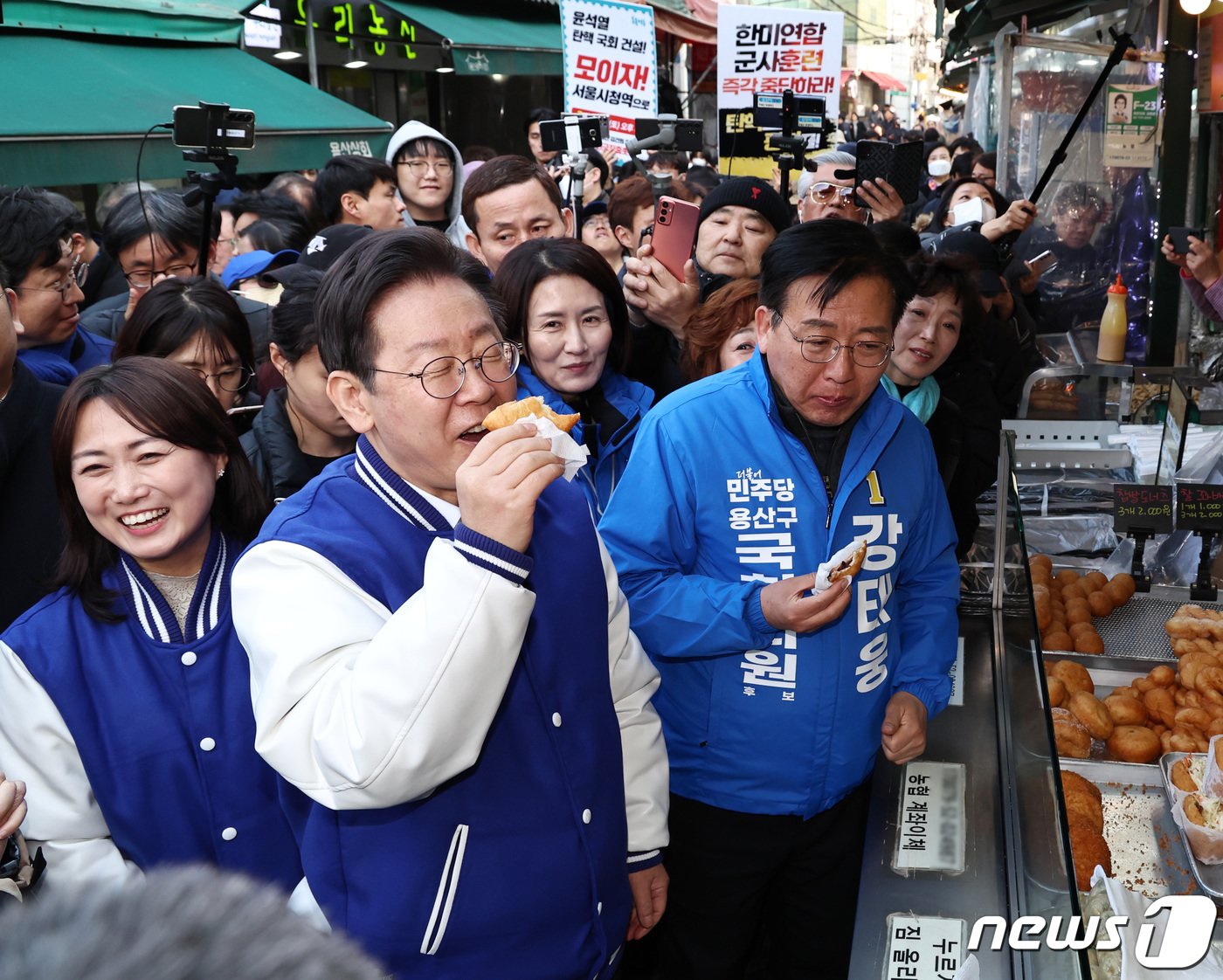 이재명 더불어민주당 대표가 13일 오후 서울 용산구 용문시장을 찾아 강태웅 후보와 함께 도너츠를 맛보고 있다. 2024.3.13/뉴스1 ⓒ News1 구윤성 기자