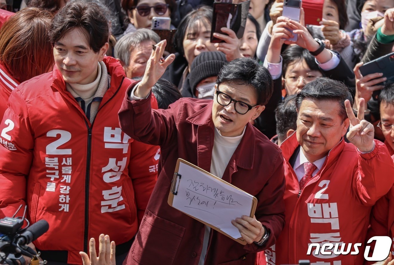 한동훈 국민의힘 비상대책위원장이 14일 부산 북구 구포시장에서 부산 지역 후보들과 &#39;잘하겠습니다 부산에!&#39;라고 적은 종이를 든 채 지지를 호소하고 있다. &#40;공동취재&#41; 2024.3.14/뉴스1 ⓒ News1 윤일지 기자