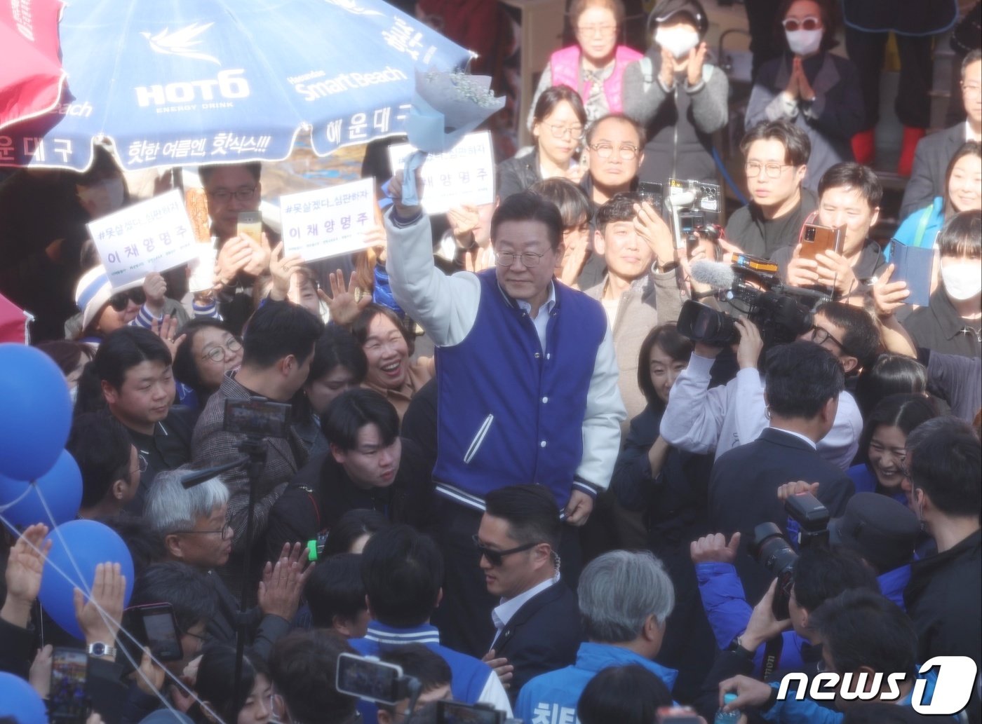 이재명 더불어민주당 대표가 15일 오후 부산 기장군 기장시장에서 지지 호소 중 시민에게 받은 꽃다발을 들어보이고 있다. &#40;공동취재&#41; 2024.3.15/뉴스1 ⓒ News1 윤일지 기자