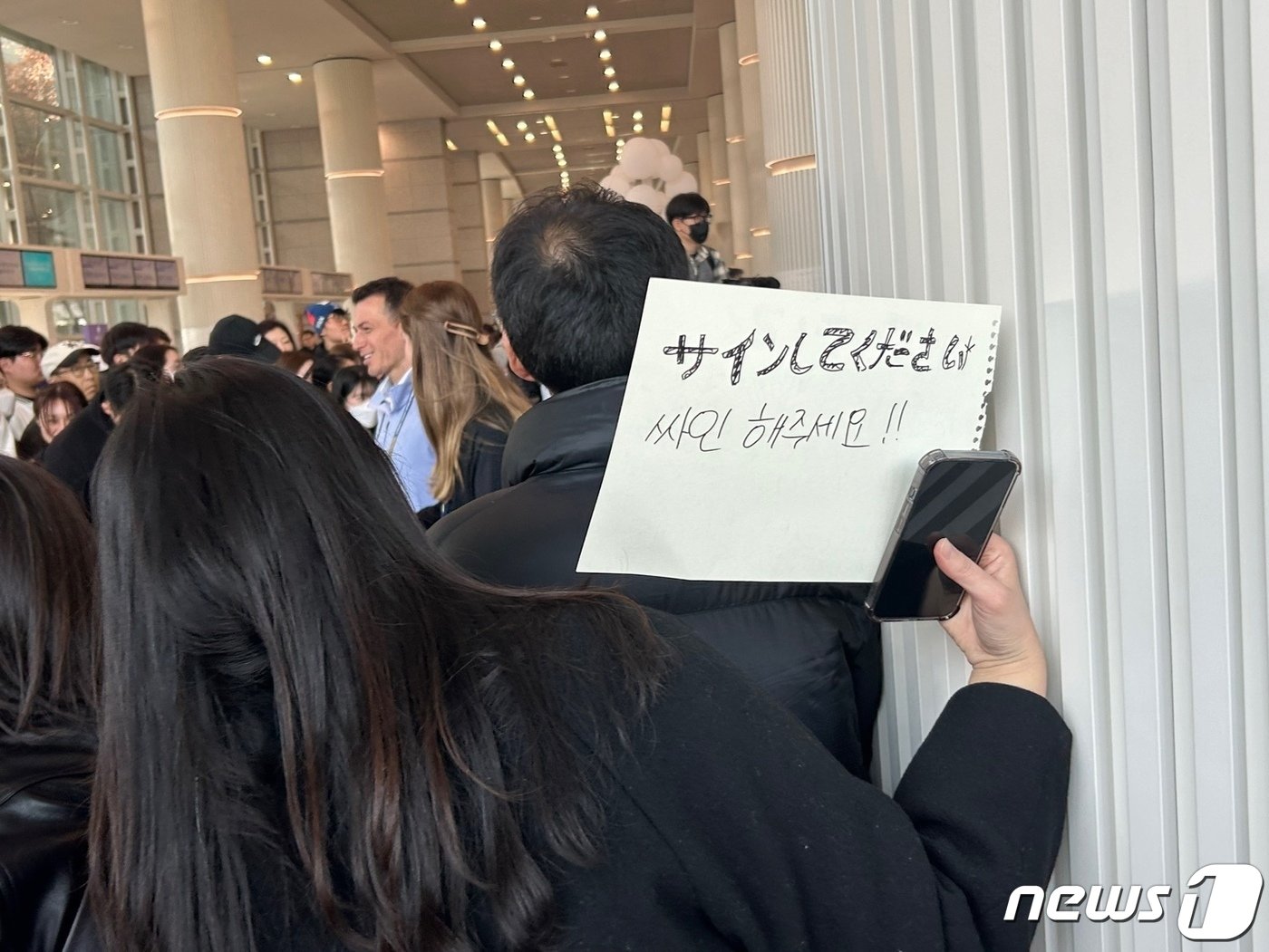 본문 이미지 -  15일 오후 인천국제공항 제1터미널에서 오타니를 기다리는 한 여성이 사인을 요구하는 피켓을 들고 있다. 2024.3.15/뉴스1 ⓒ News1 문대현 기자