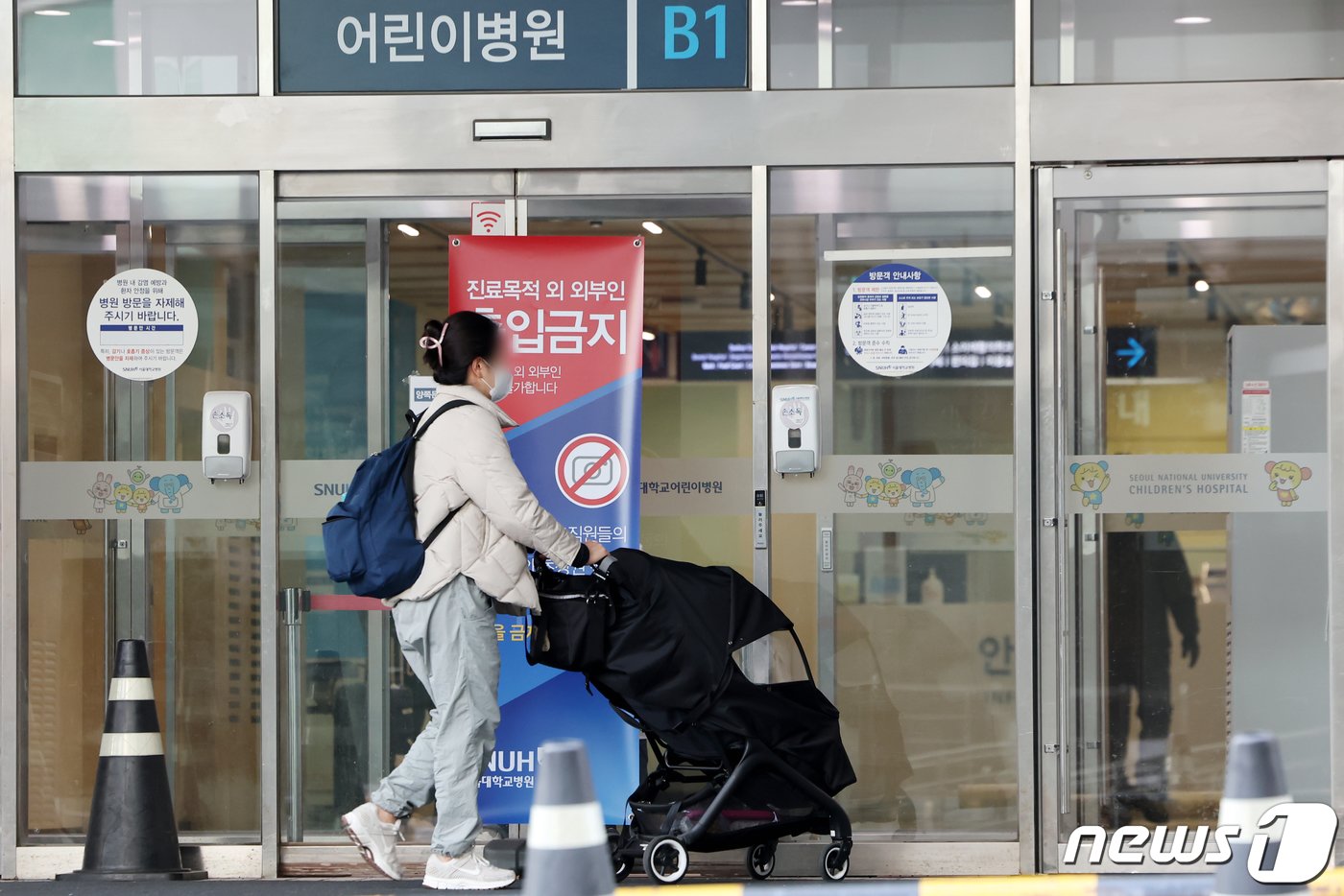 전공의들의 집단행동이 한 달째를 맞은 18일 서울의 한 대학병원에서 한 보호자가 유모차를 끌고 어린이병원으로 들어서고 있다. 2024.3.18/뉴스1 ⓒ News1 민경석 기자