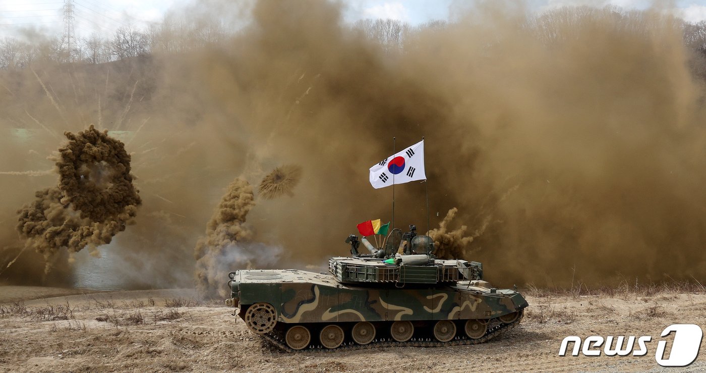 본문 이미지 - 20일 오전 경기 연천군 임진강에서 열린 한미연합 제병협동 도하훈련에서 국군 K1E1 전차가 부교 위를 지난 뒤 연막탄을 발사하고 있다. 이날 훈련에는 육군 5공병여단과 5군단 항공단·방공단·화생방대대, 5기갑여단 전차중대, 1항공여단 301항공대대 등 국군과 미2사단, 한미연합사단 11공병대대 등 470여 명이 참가했다. 훈련은 작전지역 내 교각이 붕괴된 상황을 가정해 한미 연합 장병들이 강폭 180m의 임진강에 부교를 설치, K1E1 전차 등이 강을 도하하는 능력을 키우기 위해 진행됐다. 2024.3.20/뉴스1 ⓒ News1 장수영 기자