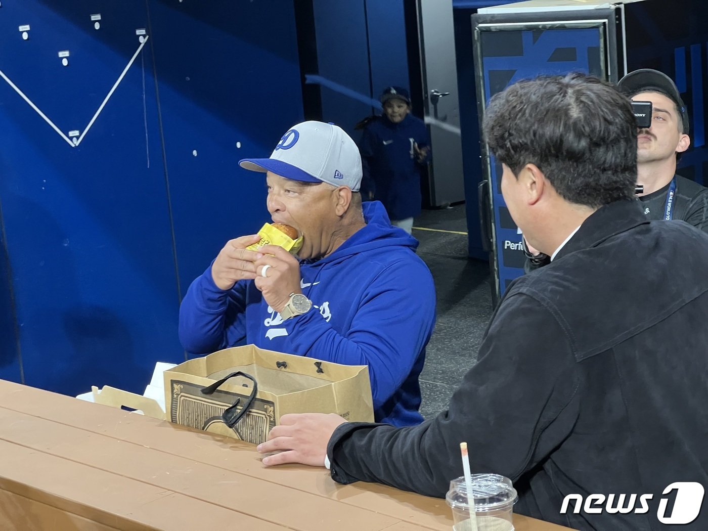 본문 이미지 - 20일 서울 구로구 고척스카이돔에서 열리는 2024 미국 메이저리그(MLB) 월드투어 서울시리즈 개막전 샌디에이고 파드리스와 로스엔젤레스(LA) 다저스의 경기를 앞두고 데이브 로버츠 다저스 감독이 올시즌 KBO리그 개막을 앞두고 한화 이글스로 전격 컴백한 류현진이 선물한 빵을 맛있게 먹고 있다. 2024.3.20/뉴스1 ⓒ News1 이상철 기자