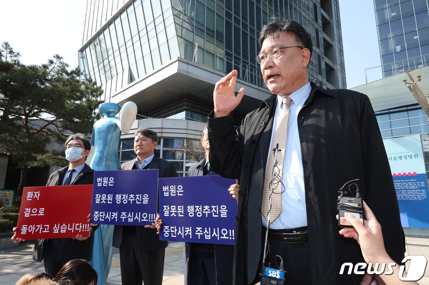 본문 이미지 - 전국 의과대학 교수협의회 소송대리인인 이병철 변호사(가운데)가 지난달 22일 오전 서울 서초구 서울행정법원에서 열린 의대 증원 취소 집행정지 사건 심문 기일에 출석하며 입장을 밝히고 있다. /뉴스1 ⓒ News1 신웅수 기자