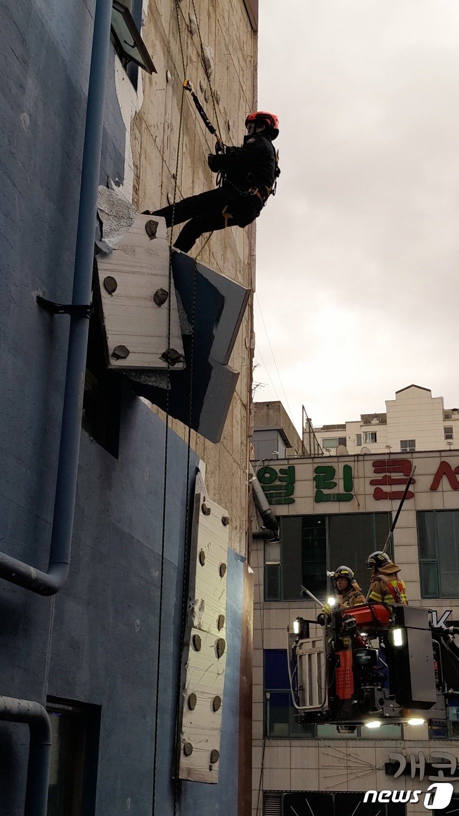 본문 이미지 - 22일 오후4시20분께 인천시 서구 왕길동의 한 주차타워에서 건물 외벽이 탈락해 추락할 것 같다는 신고가 접수돼 소방 관게자들이 안전조치를 취하고 있다.(인천소방본부 제공)/뉴스1 