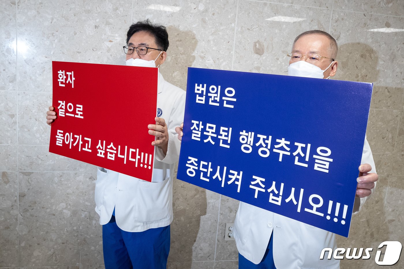 본문 이미지 - 연세대학교 의과대학 교수들이 25일 서울 서대문구 신촌 세브란스병원에서 열린 전국의과대학교수협의회의 의대정원 증원에 대한 입장발표 기자회견장 앞에서 자신들의 요구사항을 담은 손팻말을 들고 있다. 2024.3.25/뉴스1 ⓒ News1 유승관 기자
