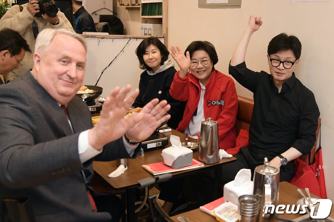 한동훈 국민의힘 총괄선거대책위원장과 이혜훈 중구성동구을 후보, 국민의미래 인요한 선거대책위원장이 25일 서울 중구 신당동 떡볶이 타운을 찾아 한 식당에서 식사를 기다리며 시민들에게 인사를 하고 있다. &#40;공동취재&#41; 2024.3.25/뉴스1 ⓒ News1 임세영 기자