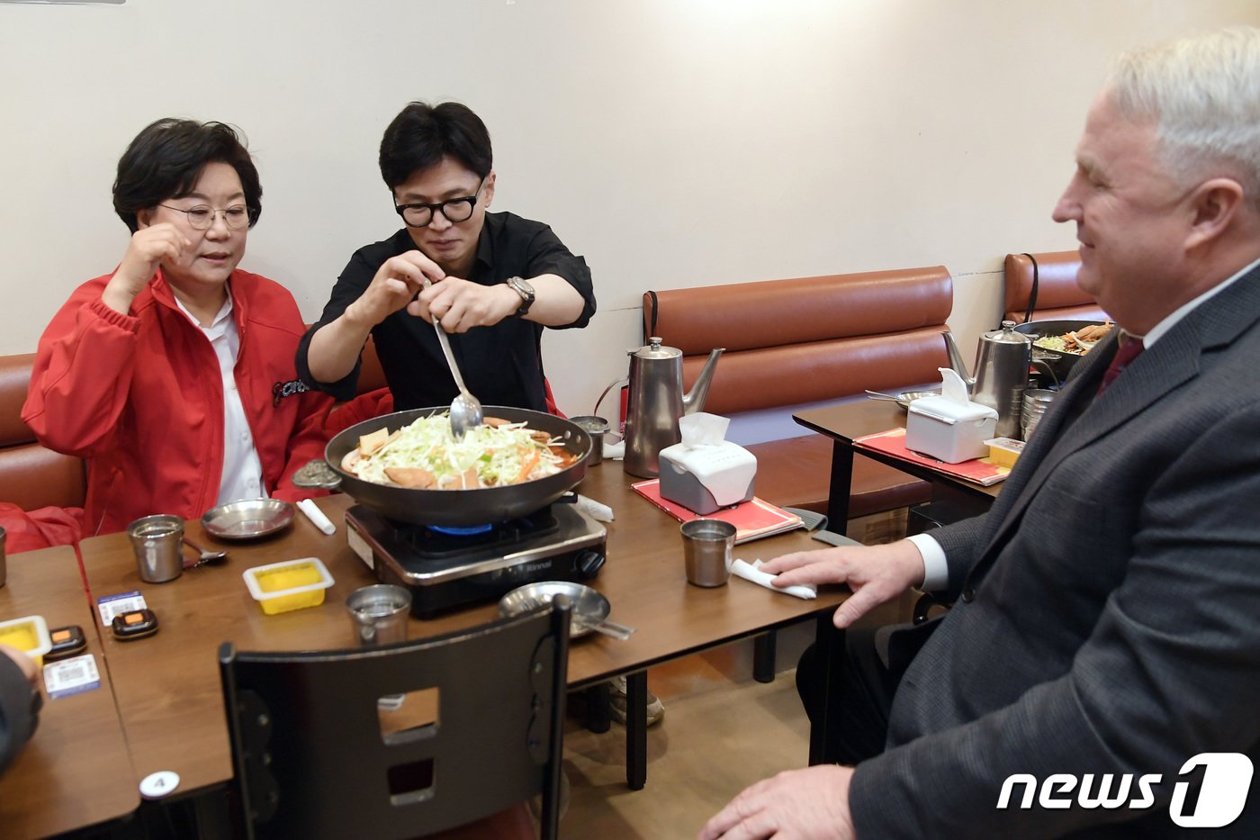 본문 이미지 - 한동훈 국민의힘 총괄선거대책위원장이 25일 서울 중구 신당동 떡볶이 타운 한 식당을 이혜훈 중구성동구을 후보, 국민의미래 인요한 선거대책위원장과 함께 찾아 떡볶이를 주문하고 국자를 들어 음식을 섞고 있다. (공동취재) 2024.3.25/뉴스1 ⓒ News1 임세영 기자