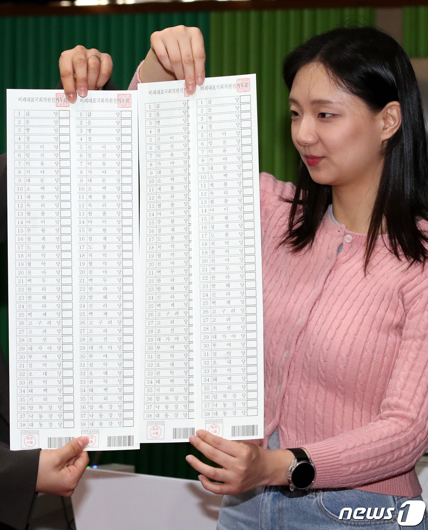 본문 이미지 - 26일 대전 중구 서대전초등학교에서 진행된 제22대 국회의원 선거 및 중구청장 재선거 대비 사전투표 모의시험에서 중구청 직원들이 비례대표 국회의원 선거 투표용지를 들어 보이고 있다. 2024.3.26 /뉴스1 ⓒ News1 김기태 기자