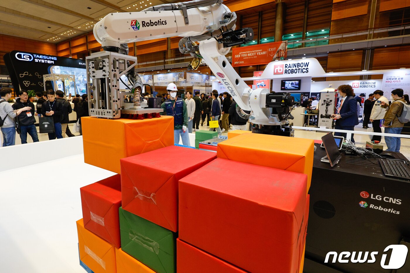본문 이미지 - 지난해 3월 27일 서울 강남구 코엑스에서 열린 아시아 대표 스마트공장∙자동화산업전(Smart Factory+Automation World 2024)을 찾은 관람객들이 LG CNS 부스에서 산업용 자율주행로봇을 보고 있다.2024.3.27/뉴스1 ⓒ News1 안은나 기자