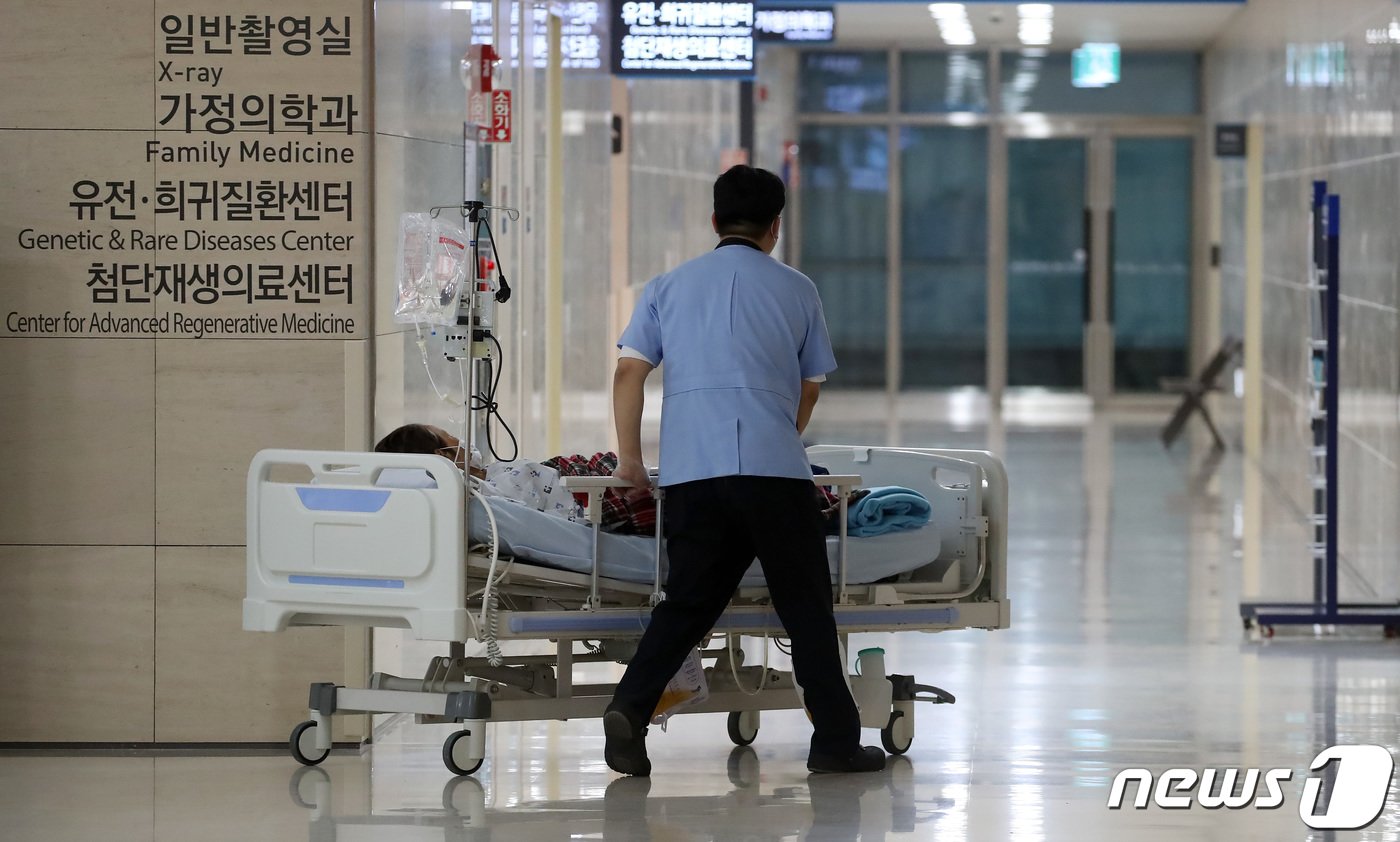 본문 이미지 - 정부의 의대 증원에 반발하는 전공의 집단이탈과 의대교수 사직서 제출로 의료공백이 불가피해진 가운데 27일 대구의 한 대학병원에서 의료진이 환자의 병상을 밀며 이동하고 있다. 2024.3.27/뉴스1 ⓒ News1 공정식 기자