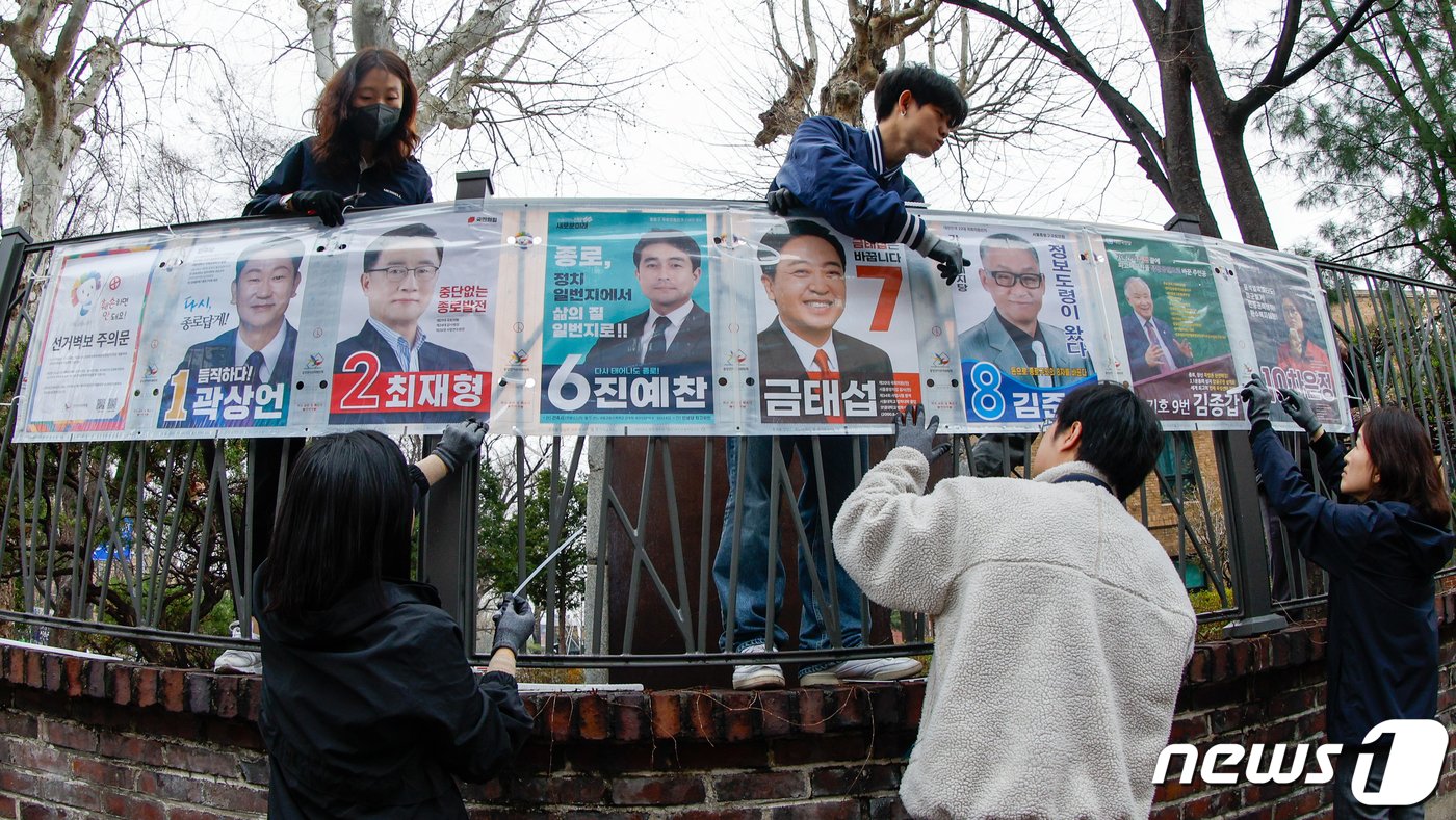 본문 이미지 - 제22대 국회의원 선거(4·10 총선) 공식 선거운동이 시작된 28일 서울시선거관리위원회 관계자들이 종로구 동숭길에서 선거벽보를 붙이고 있다. 2024.3.28/뉴스1 ⓒ News1 안은나 기자