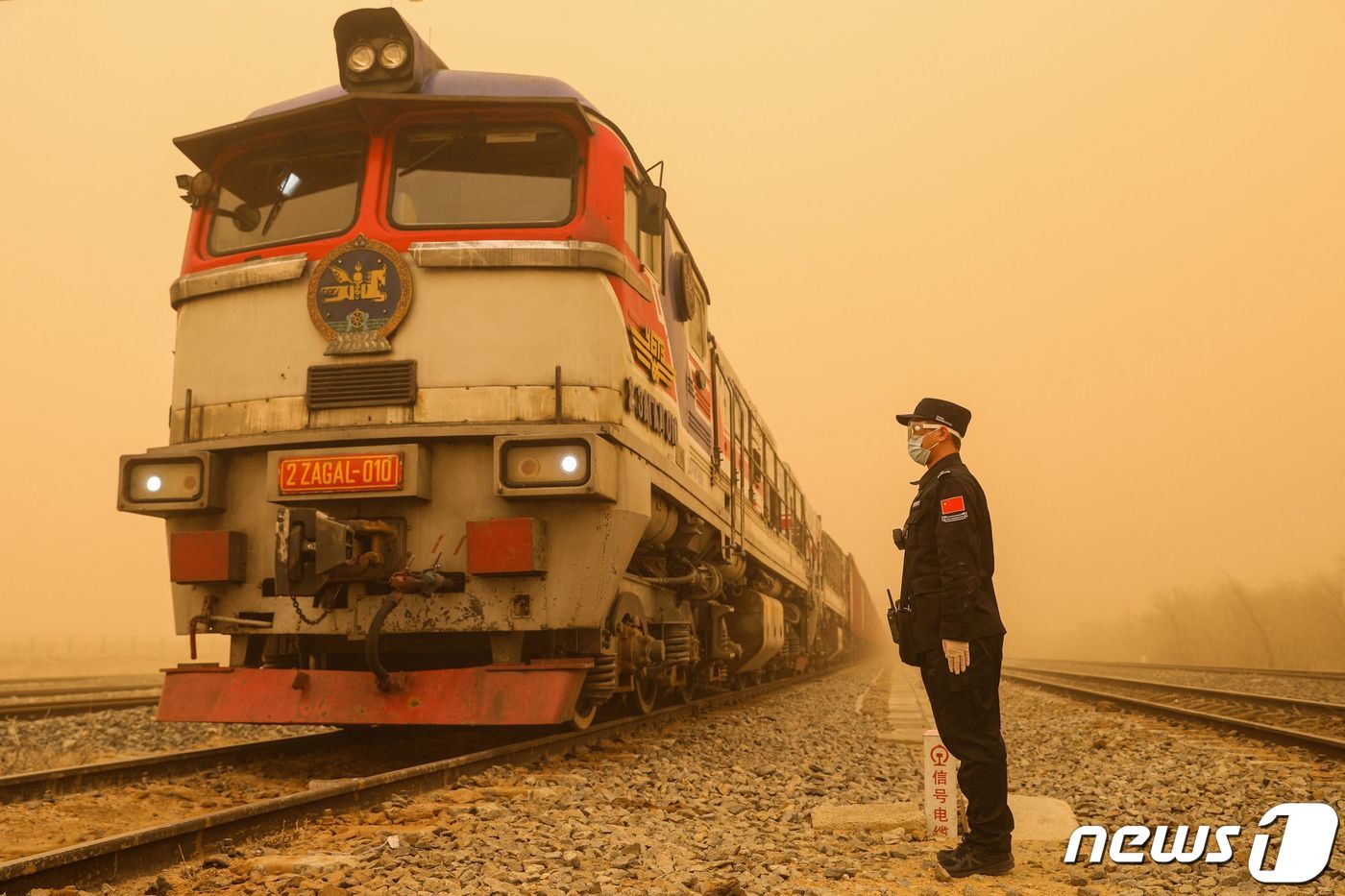 (에렌호트 AFP=뉴스1) 우동명 기자 = 27일(현지시간) 중국 내몽골자치구 에렌호트의 국경 검문소의 짙은 황사 속에 마스크를 쓴 경찰이 서 있다. 2024.3. 29ⓒ AFP= …
