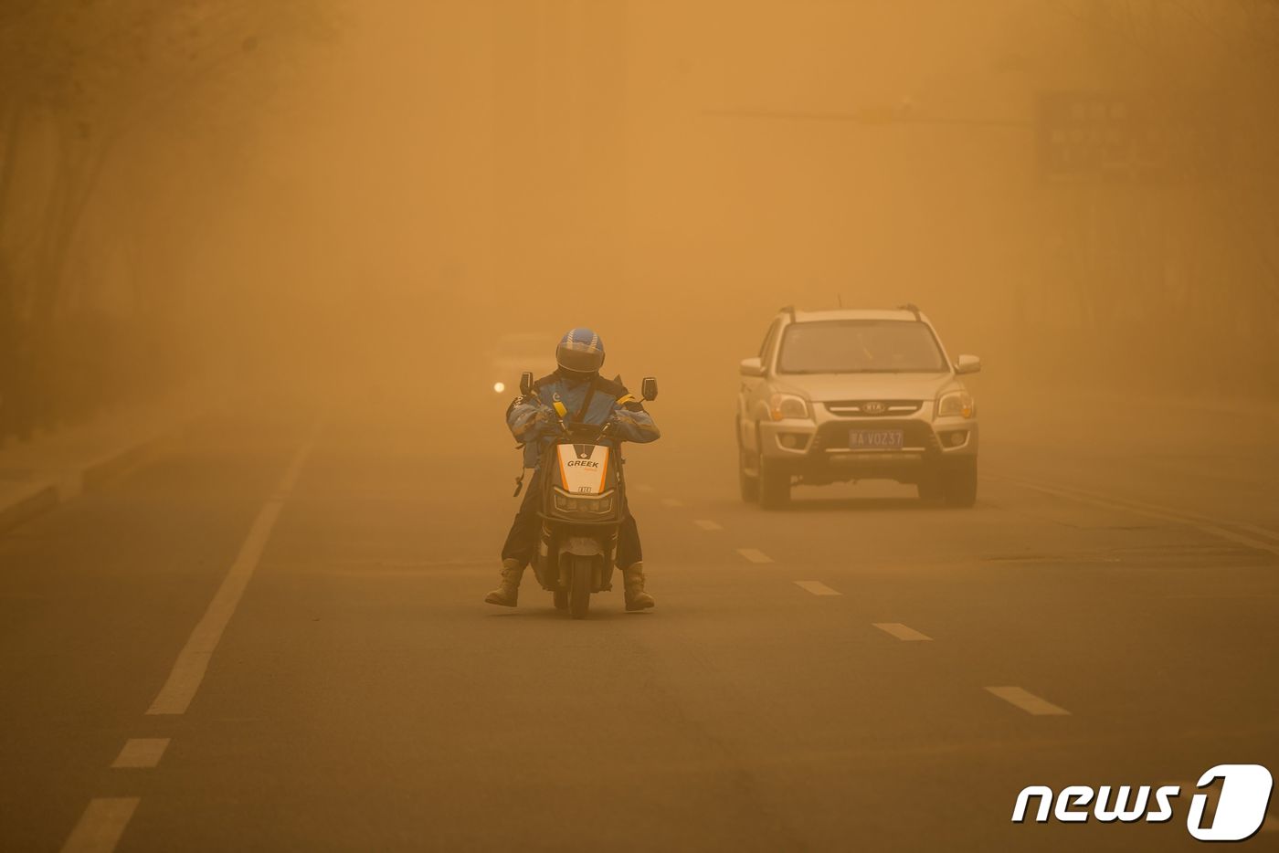 (에렌호트 AFP=뉴스1) 우동명 기자 = 27일(현지시간) 중국 내몽골 자치구 에렌호트의 거리에서 주민이 짙은 황사 속에 오토바이를 타고 있다. 2024.3. 29ⓒ AFP=뉴스 …
