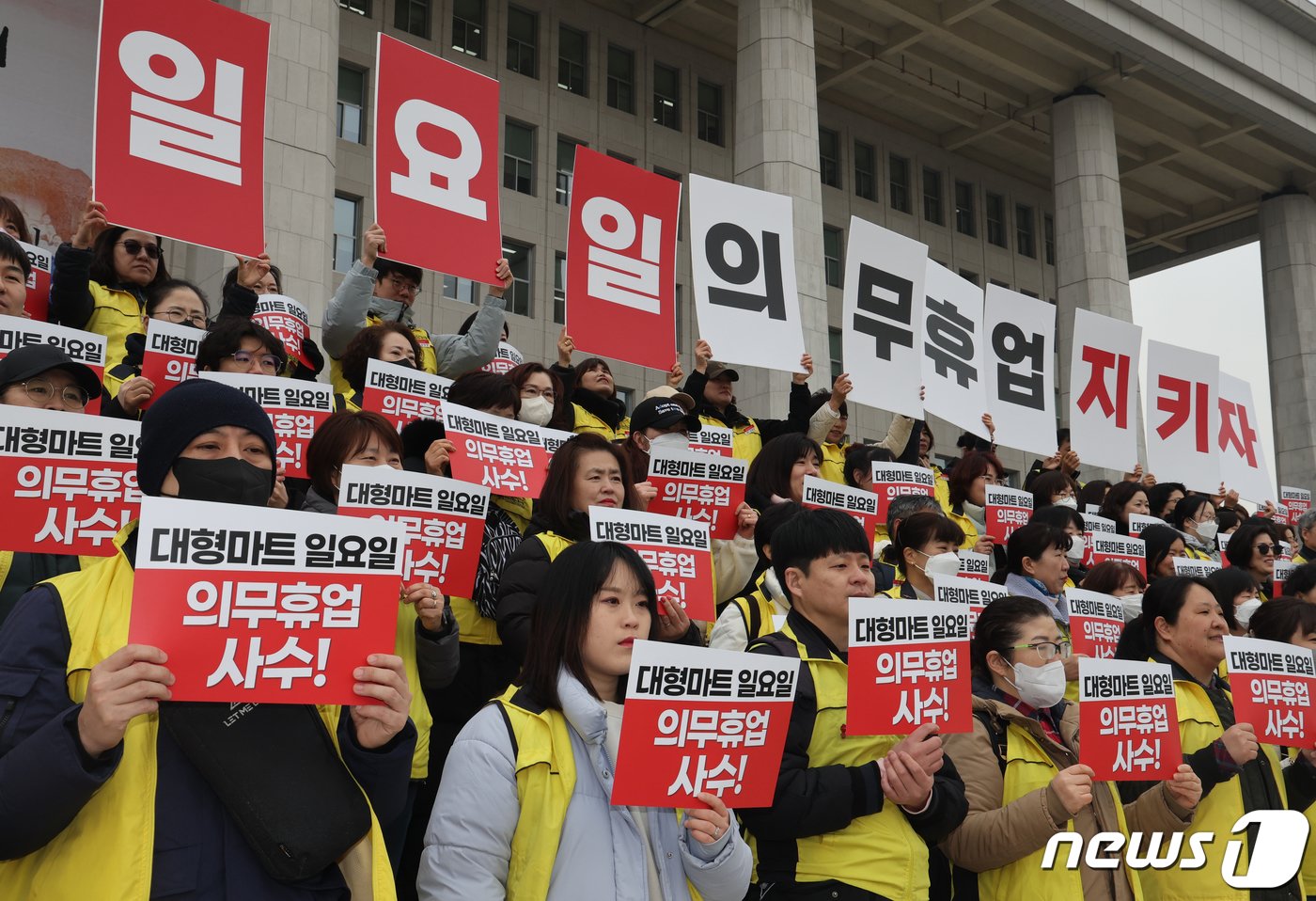 민주노총 서비스연맹 마트산업노조 회원들이 5일 서울 여의도 국회 본청 앞에서 열린 &#39;일요일 의무휴업 사수 선언, 마트노동자 300인 기자회견&#39;에서 손피켓을 들고 구호를 외치고 있다. 2024.3.5/뉴스1 ⓒ News1 송원영 기자