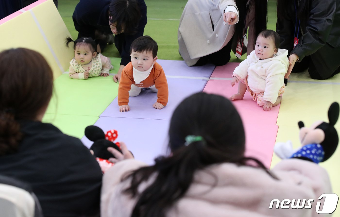 본문 이미지 - 7일 대구 북구 엑스코에서 개막한 '제39회 대구베이비&키즈페어(대구베키)'의 부대행사로 열린 생후 12개월 이하 아기들의 경주 '컴 온 베이비(come on baby)' 이벤트에 출전한 아기들이 아빠·엄마의 손짓을 바라보며 결승선을 향해 다가가고 있다.  2024.3.7/뉴스1 ⓒ News1 공정식 기자