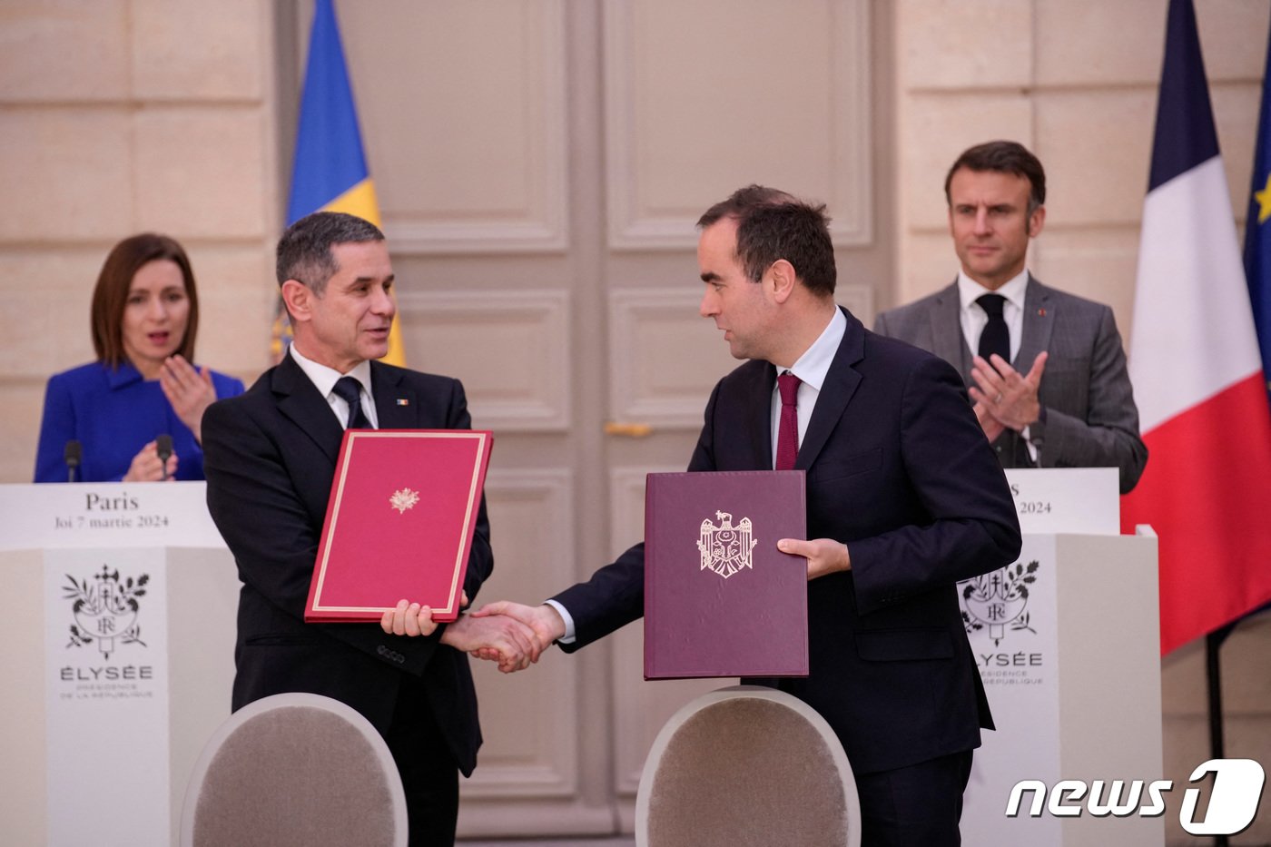 본문 이미지 - 7일(현지시간) 프랑스 파리 엘리제궁에서 세바스티앙 르코르뉘 프랑스 국방장관(오른쪽)과 아나톨리 노사티 몰도바 국방장관이 서명한 협정문을 교환하며 악수하고 있다. 이들 뒤에 선 에마뉘엘 마크롱 프랑스 대통령(오른쪽)과 마이아 산두 몰도바 대통령은 박수를 보냈다. 2024.3.7. ⓒ 로이터=뉴스1 ⓒ News1 김성식 기자
